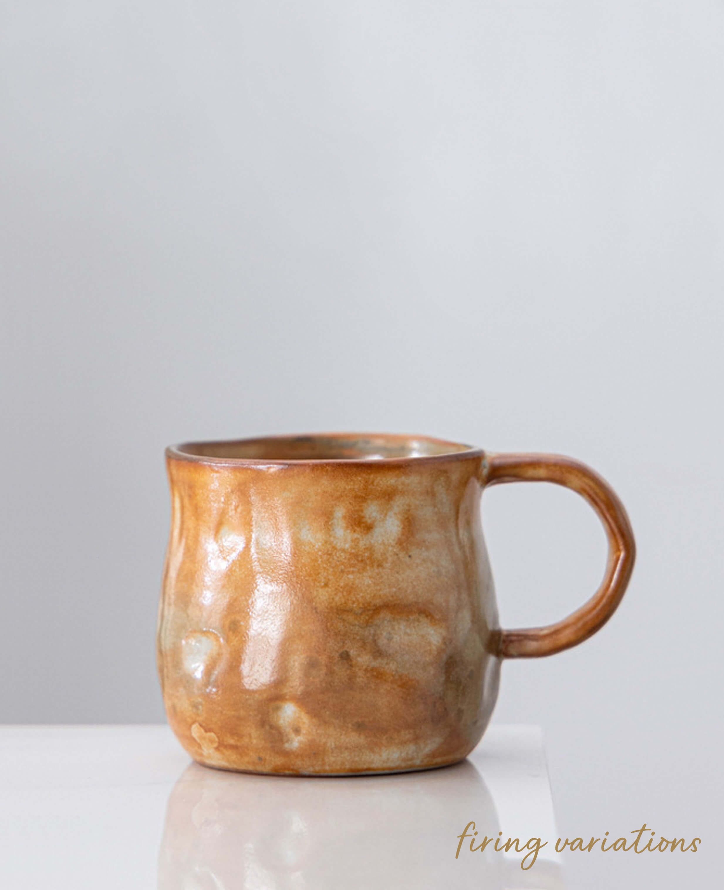 stoneware coffee and tea cup front view snowcrest wood fired flame darker glaze against grey moody background