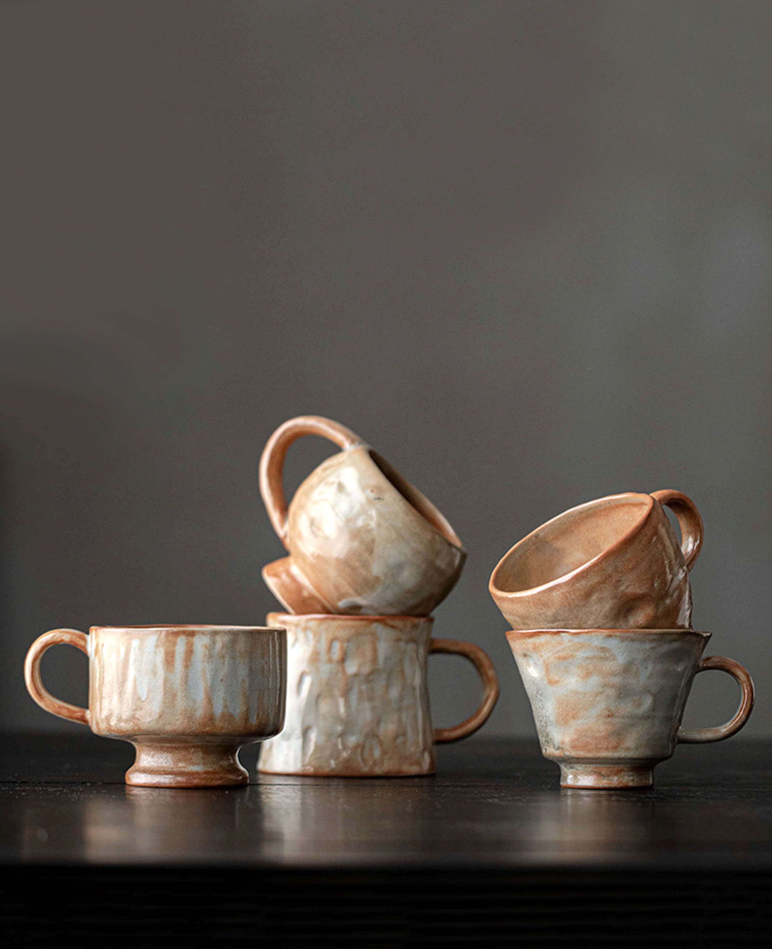 dawn chalice artisan stoneware ceramic coffee tea mugs from clayshade collection handcrafted pottery stacked display on wooden table