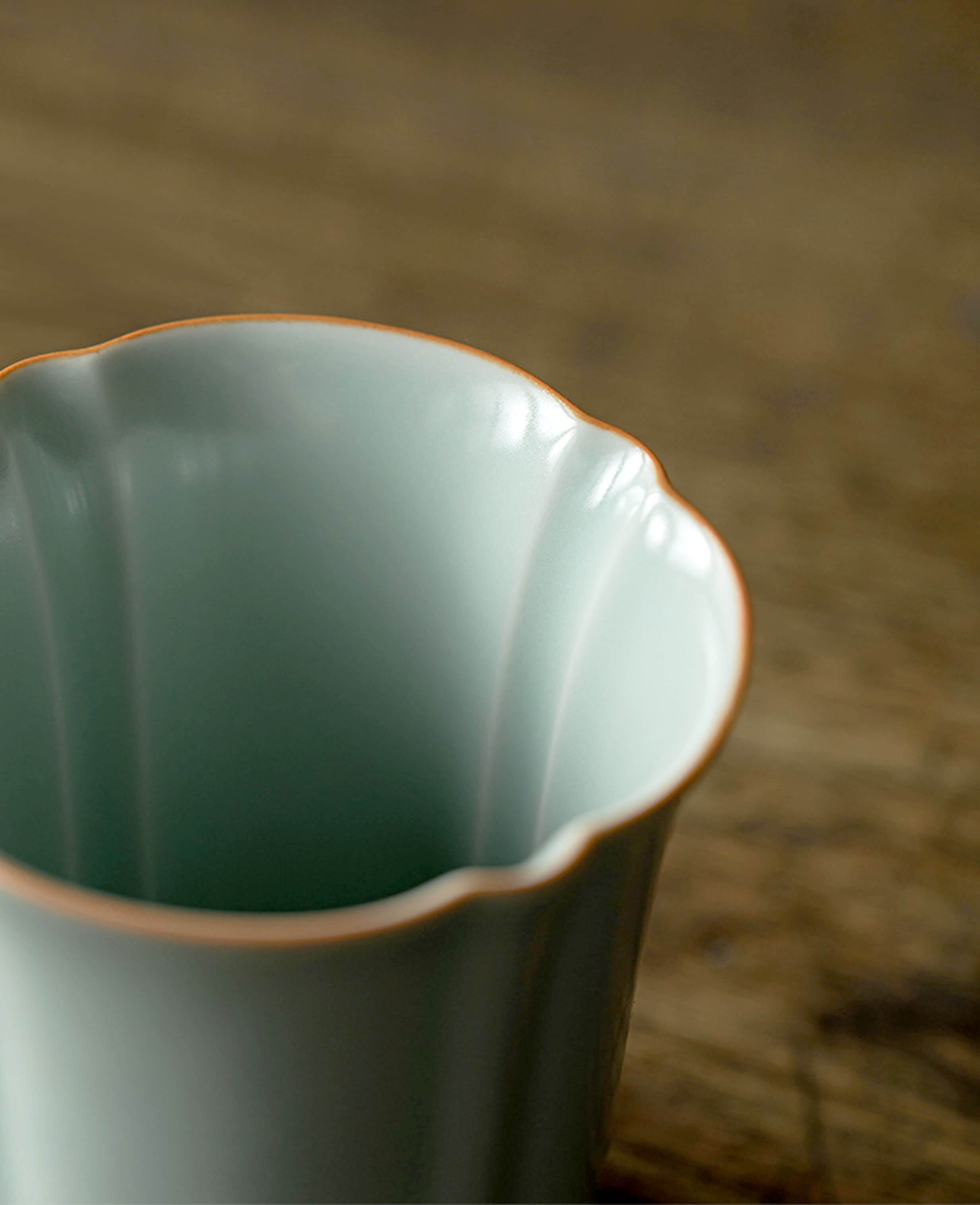 closeup of scalloped rim and smooth celadon glaze of echo of ru porcelain mug