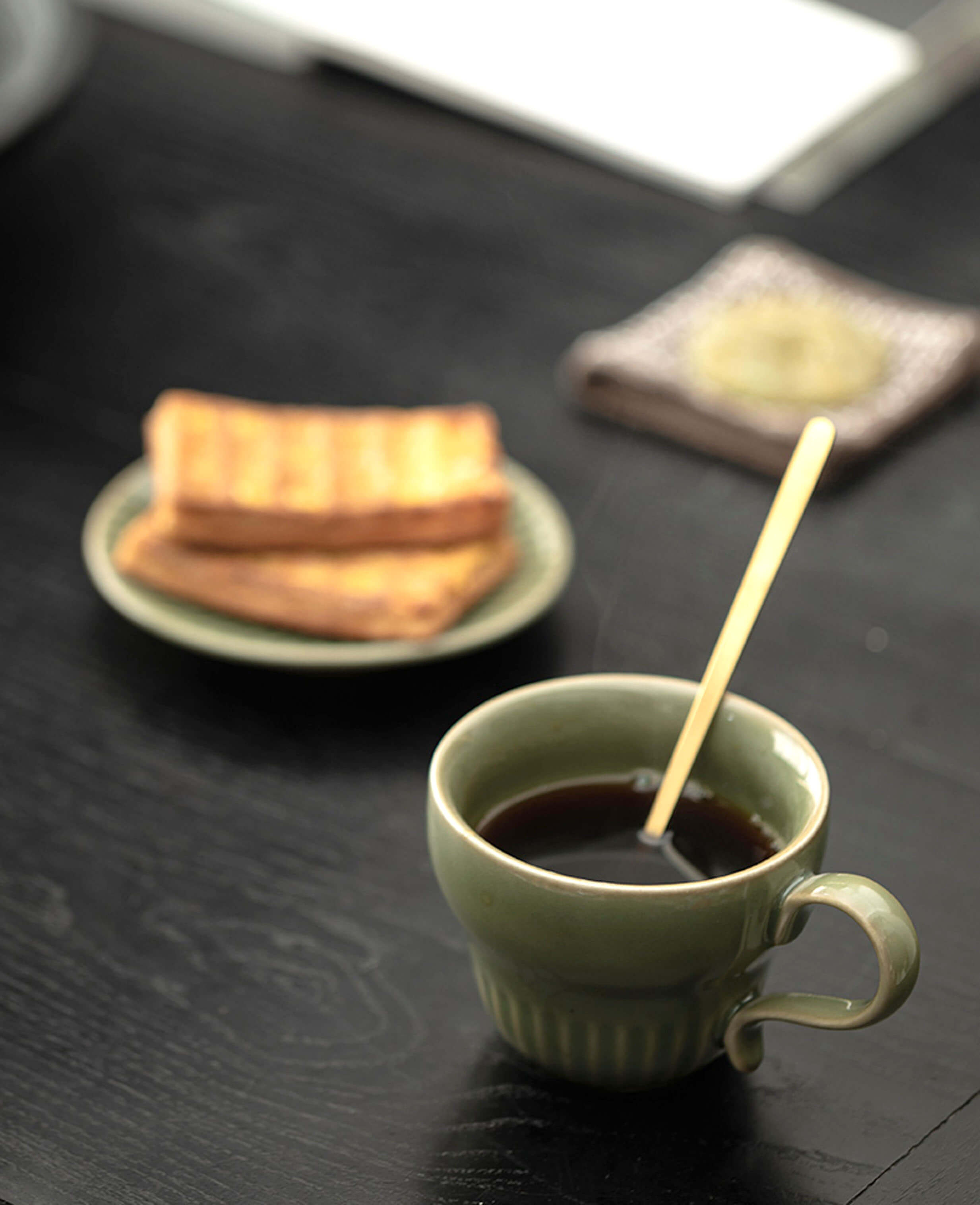 greenstill crest green porcelain tea cup with black coffee in elegant breakfast setting