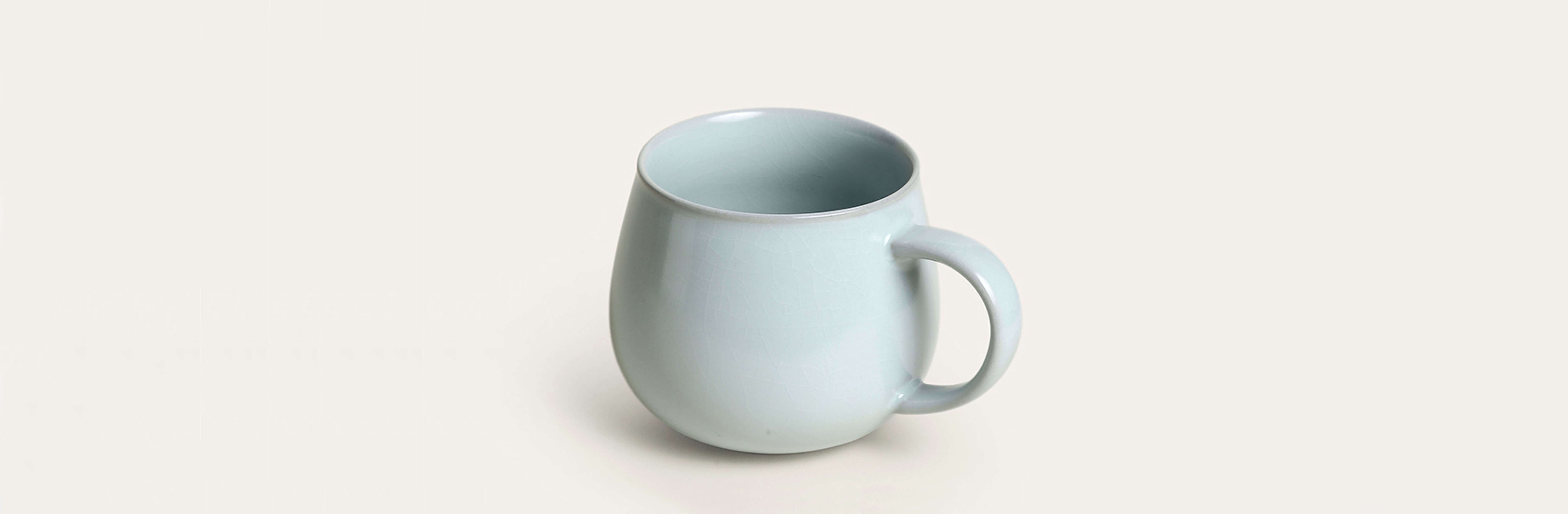 soft blue porcelain coffee mug with celadon crackle glaze shown in side profile as hero slide on ts & cs homepage