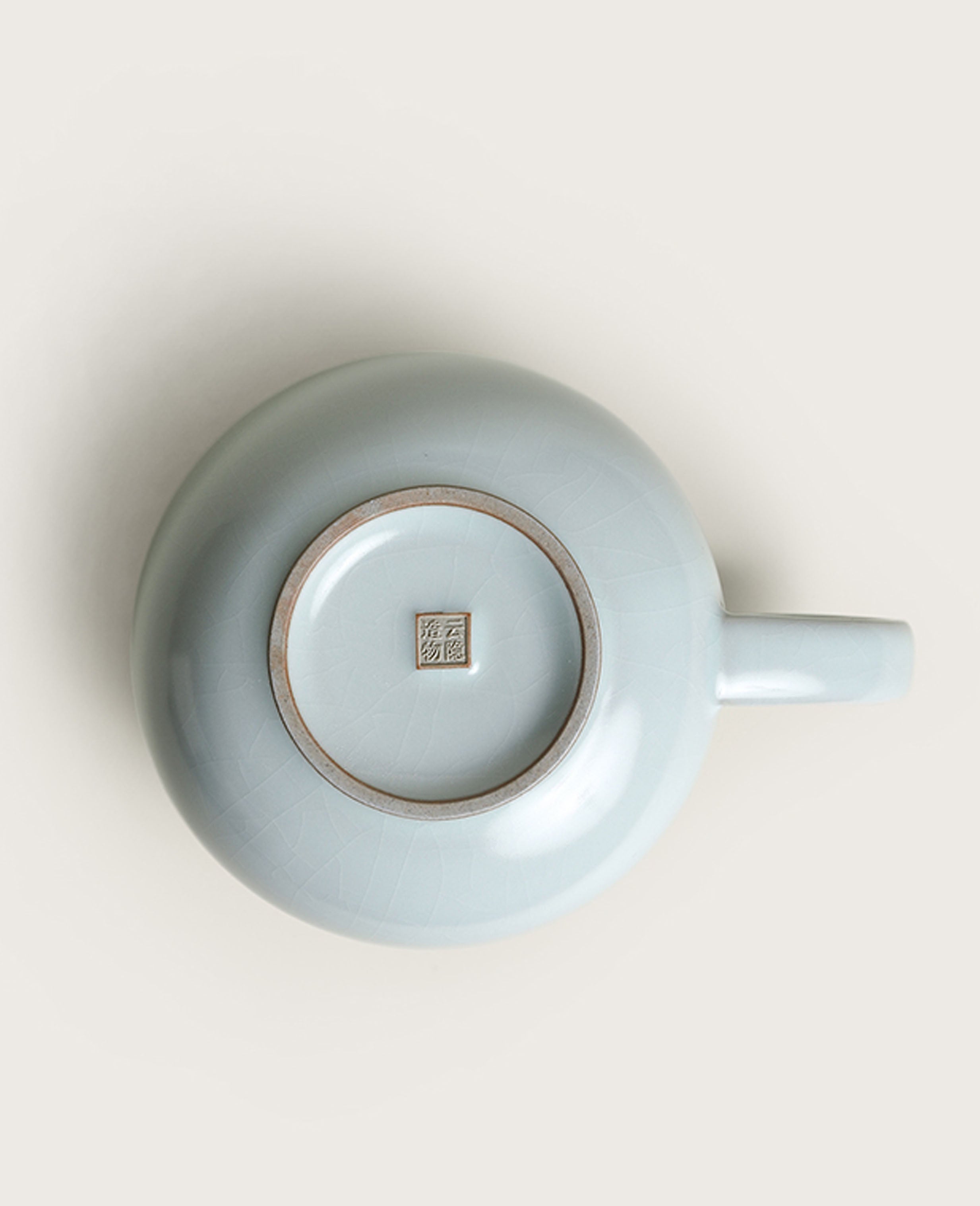 bottom view of celadon porcelain mug showing foot ring and ru style crackle glaze