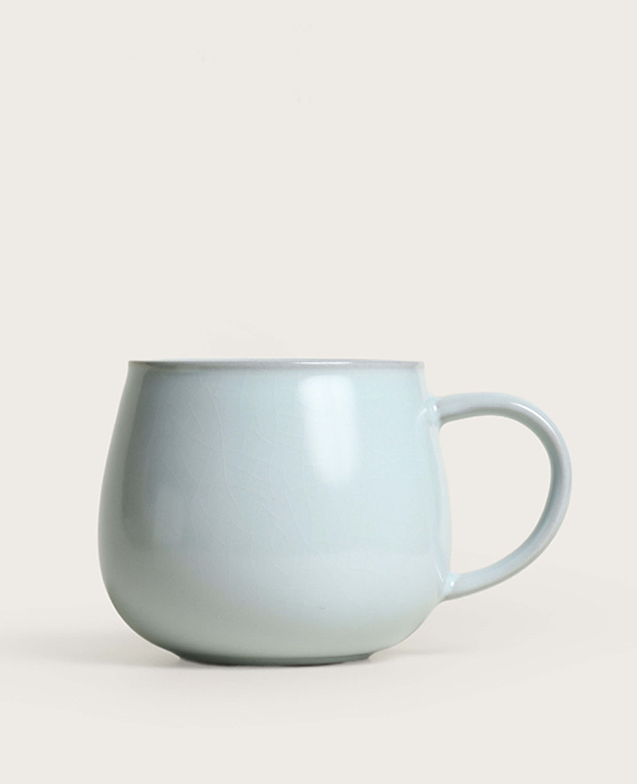 front view of round porcelain coffee mug in celadon glaze inspired by ru ware