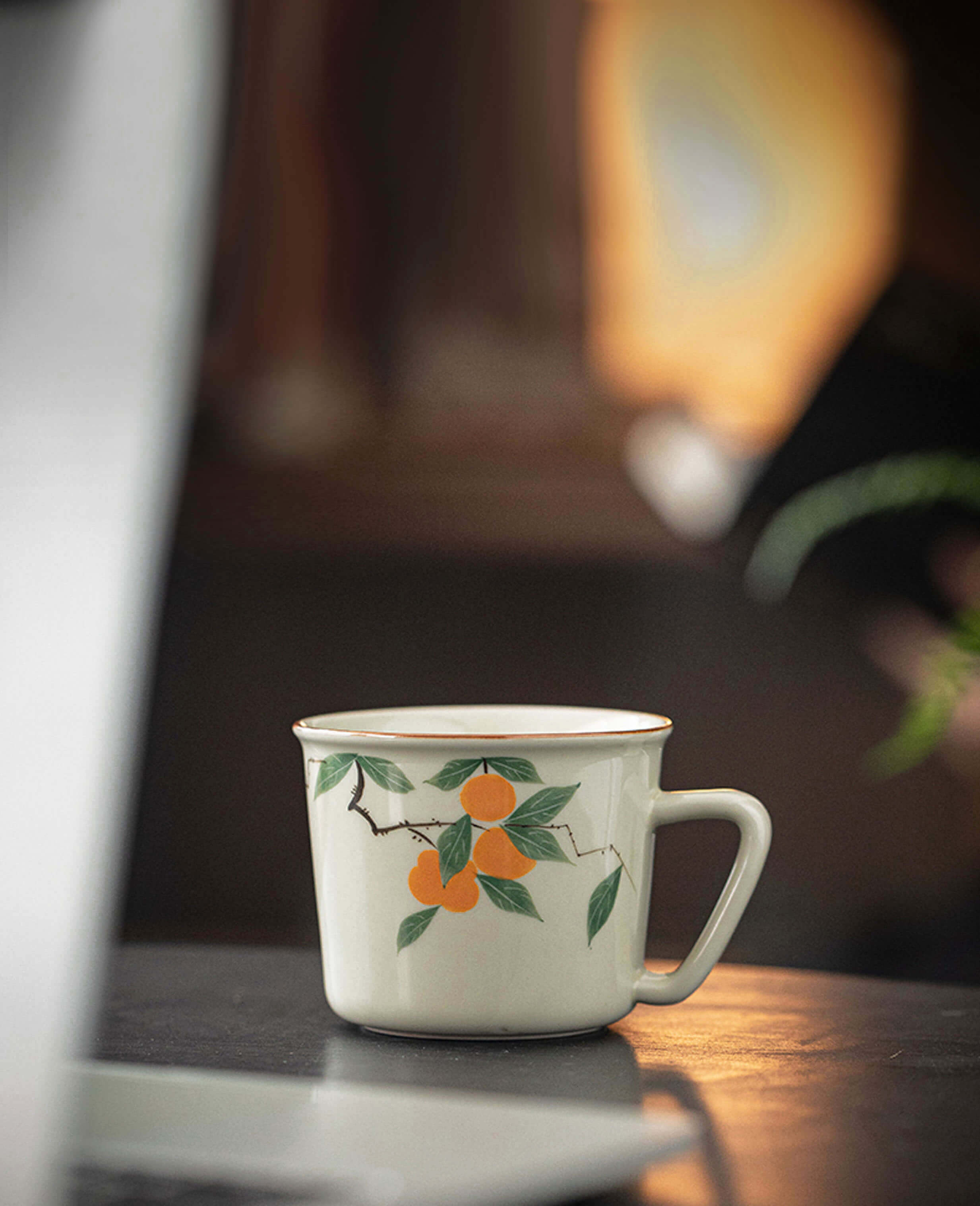 mellow blessing porcelain tea and coffee cup with persimmon pattern on dark wooden desk morning light painted diary collection