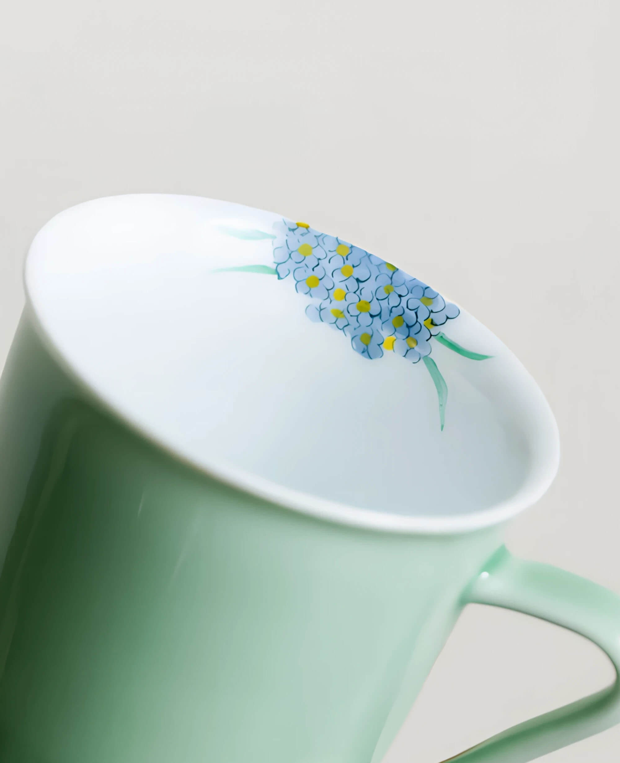 interior view of minted memory porcelain coffee and tea cup showing hand painted blue floral detail inside the rim