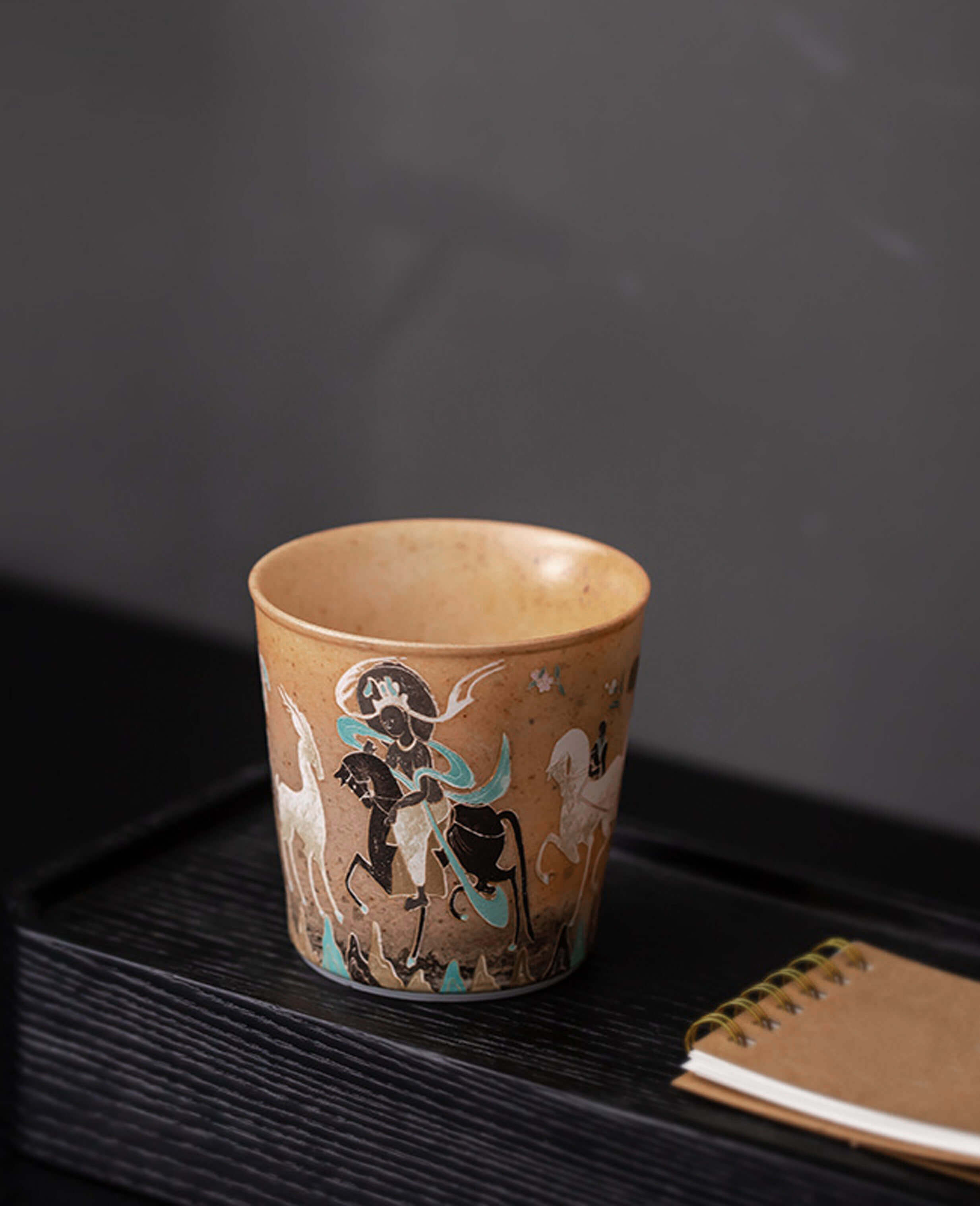 moonlit journey handcrafted ceramic tea and coffee cup on a black tray with a calendar featuring dunhuang style rider art