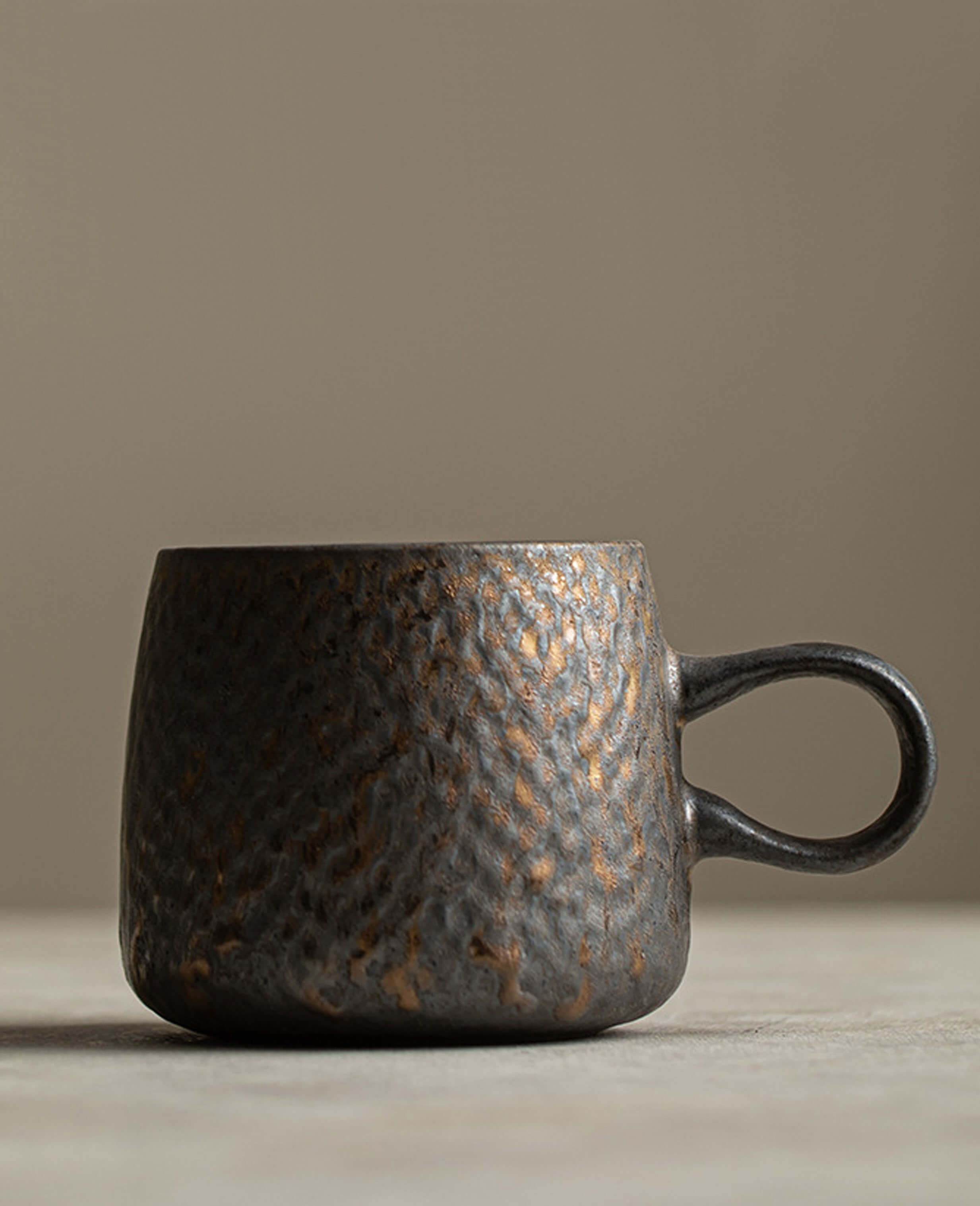 a clean side profile of the rustglow lumen coffee cup, showing its gently curved form and dark earthy glaze