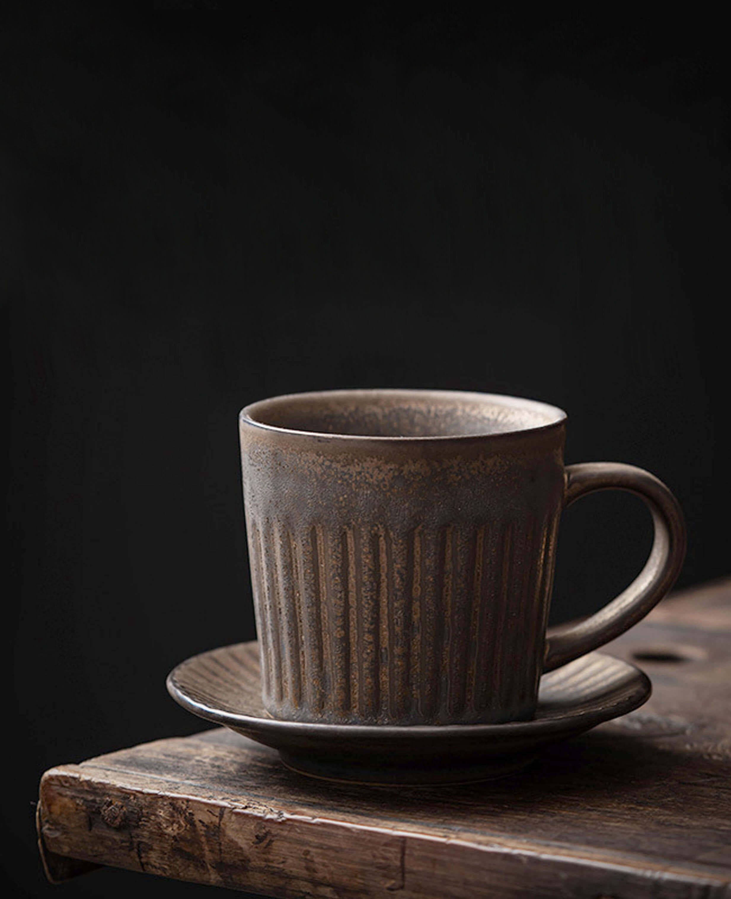 rustglow strata vintage style ceramic coffee cup in dark glaze captured against a deep black background