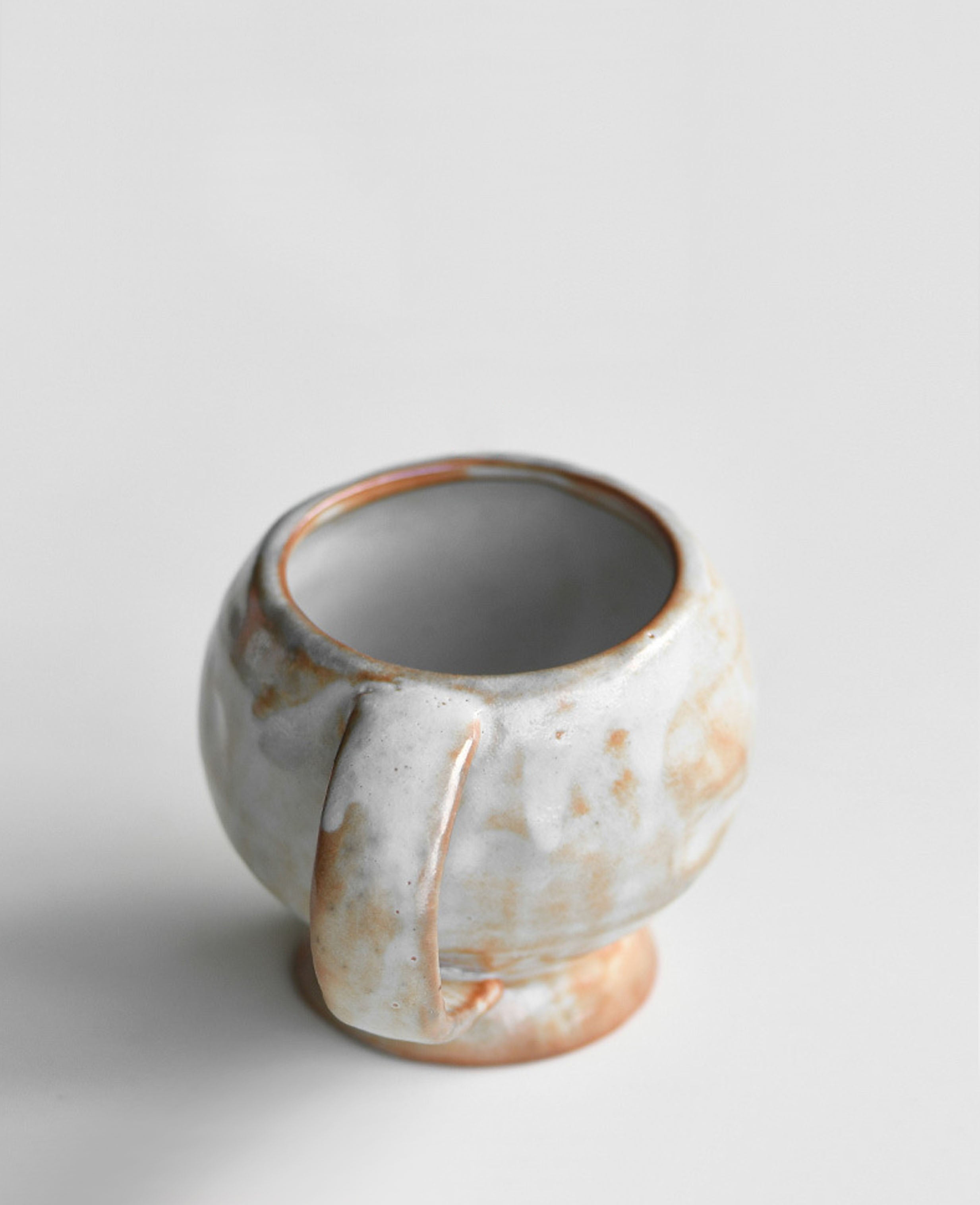 solterra handcrafted ceramic cup with organic handle and terracotta white ash glaze viewed from above
