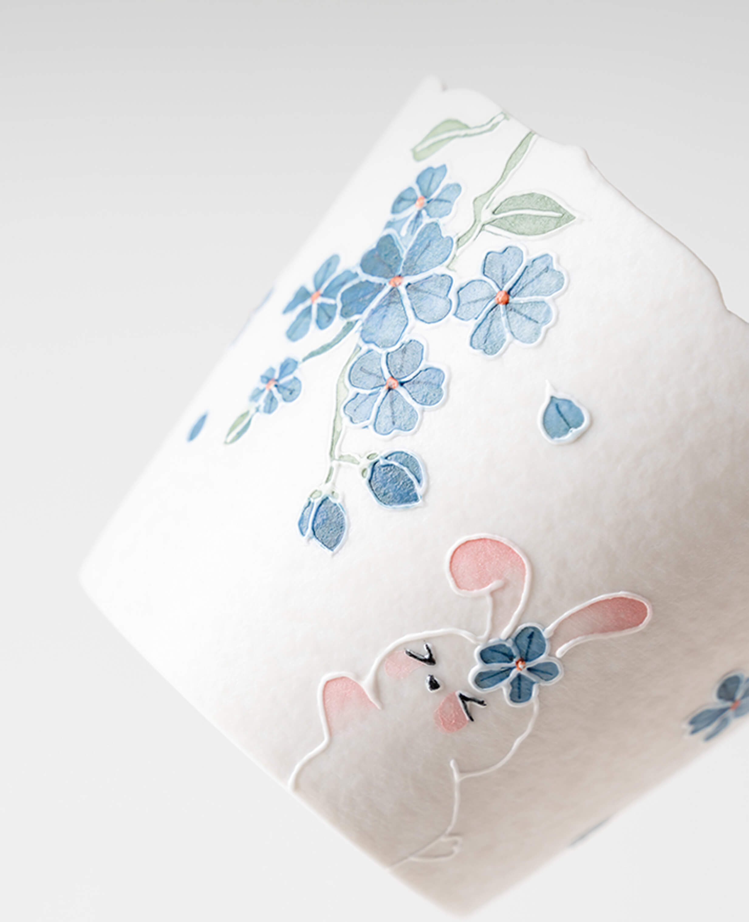 spring reunion hand painted porcelain cup for coffee and tea with cute bunny and delicate blue flower close up detail