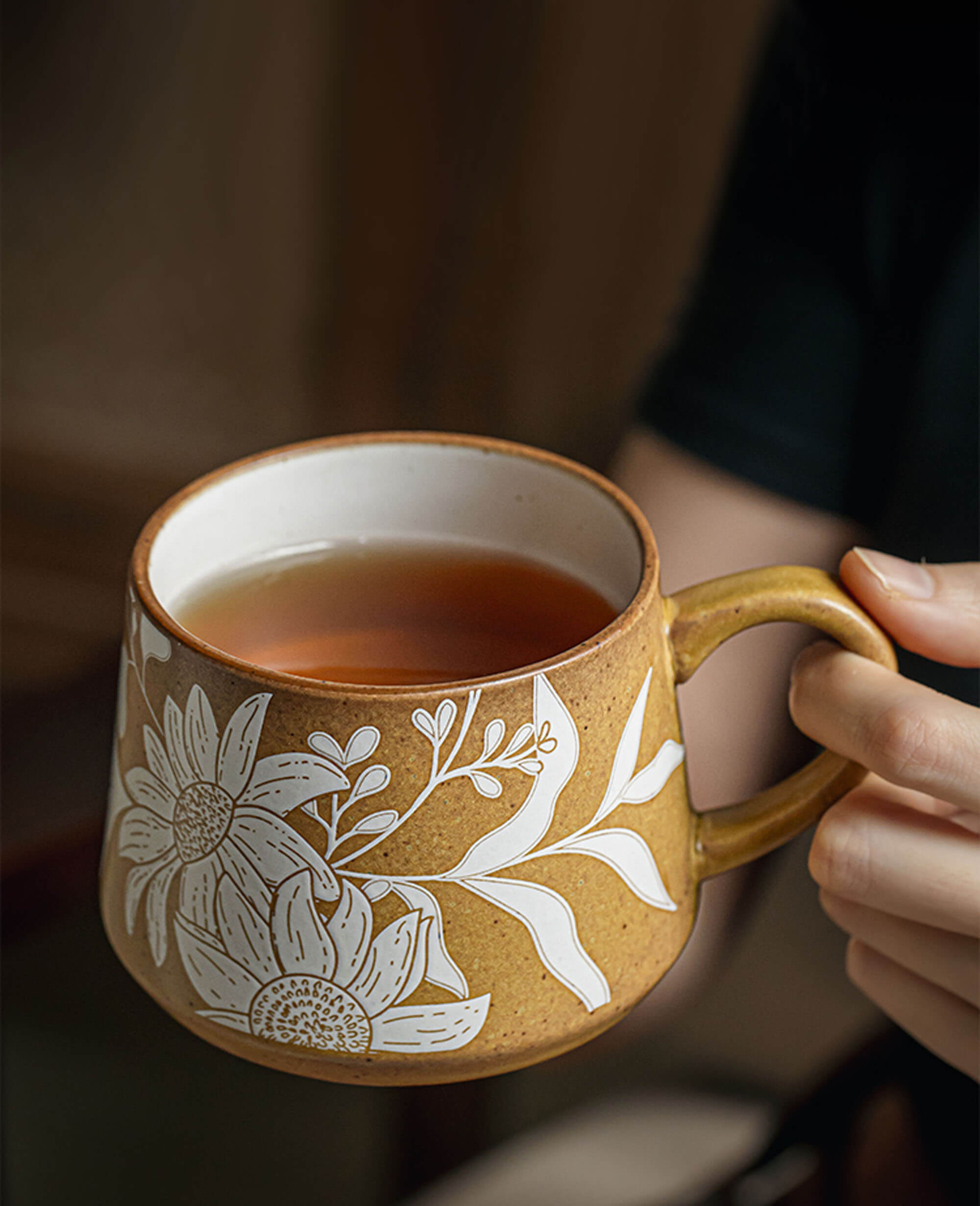 stoneware mug with botanical sketch design held in hand warm tea scene with summer ambiance