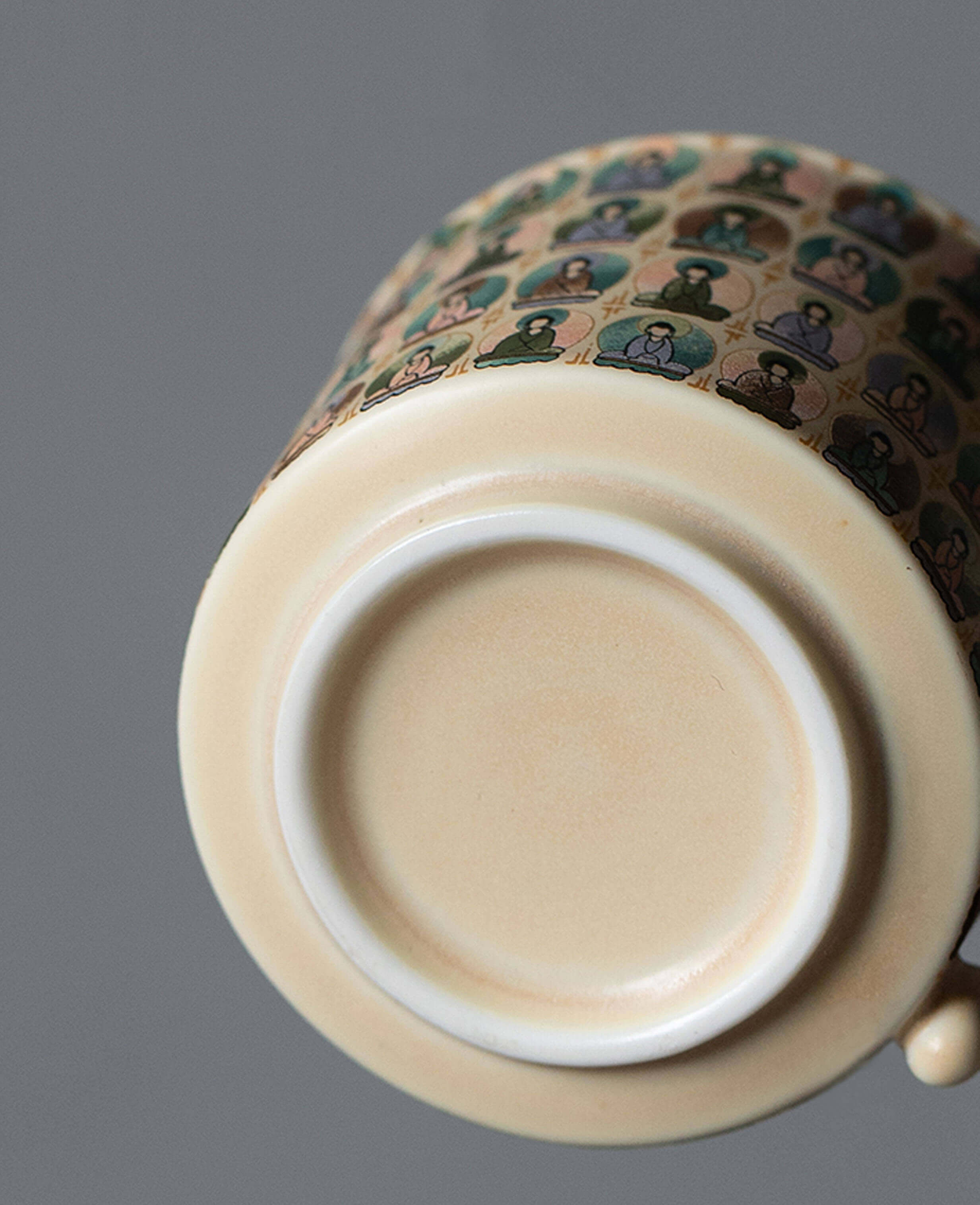 bottom view of ceramic coffee cup with smooth base and thousand buddhas design inspired by ancient murals