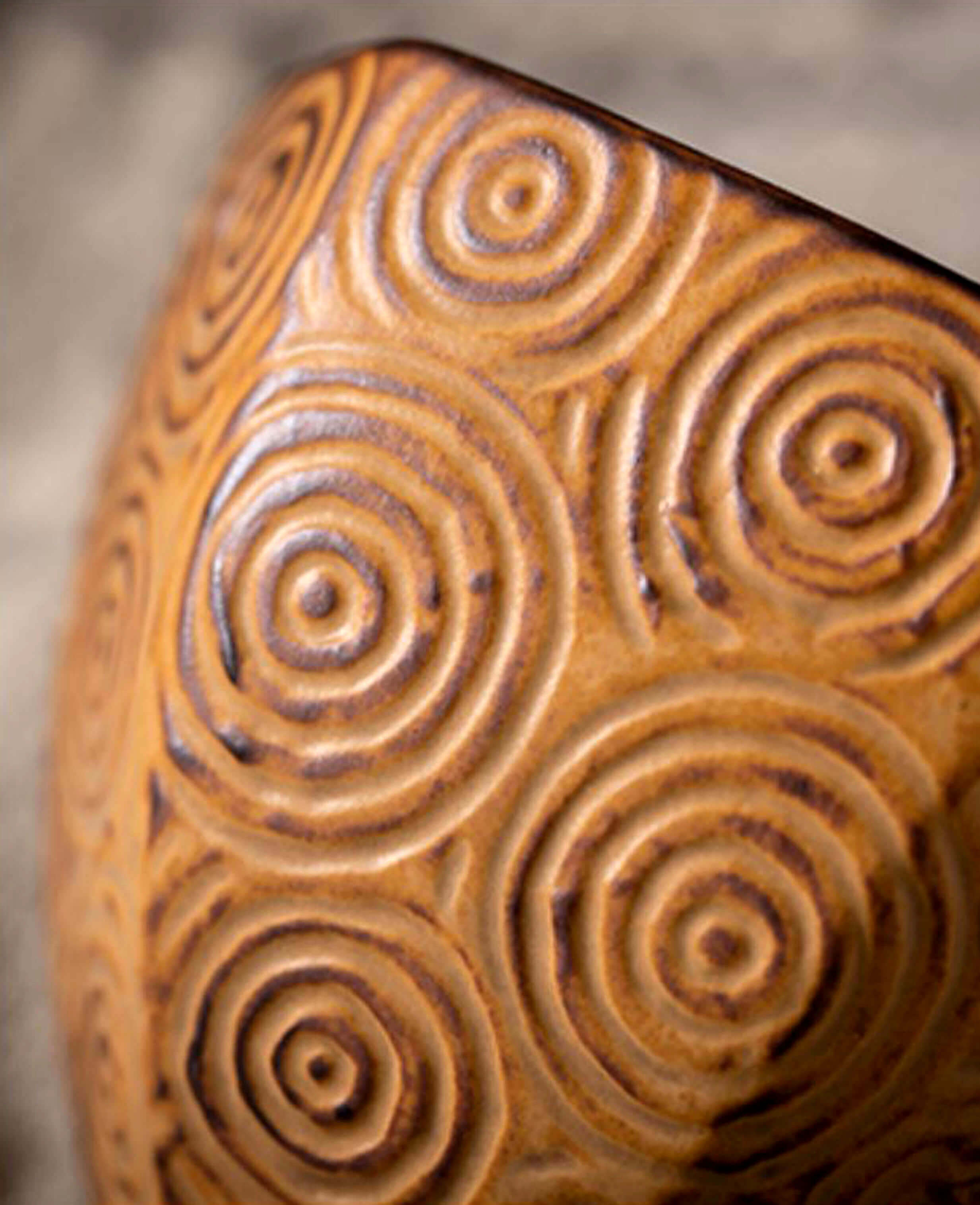 close up of spiral texture on the toffee glaze mirage ceramic coffee cup highlighting its hand carved detail and earthy glaze