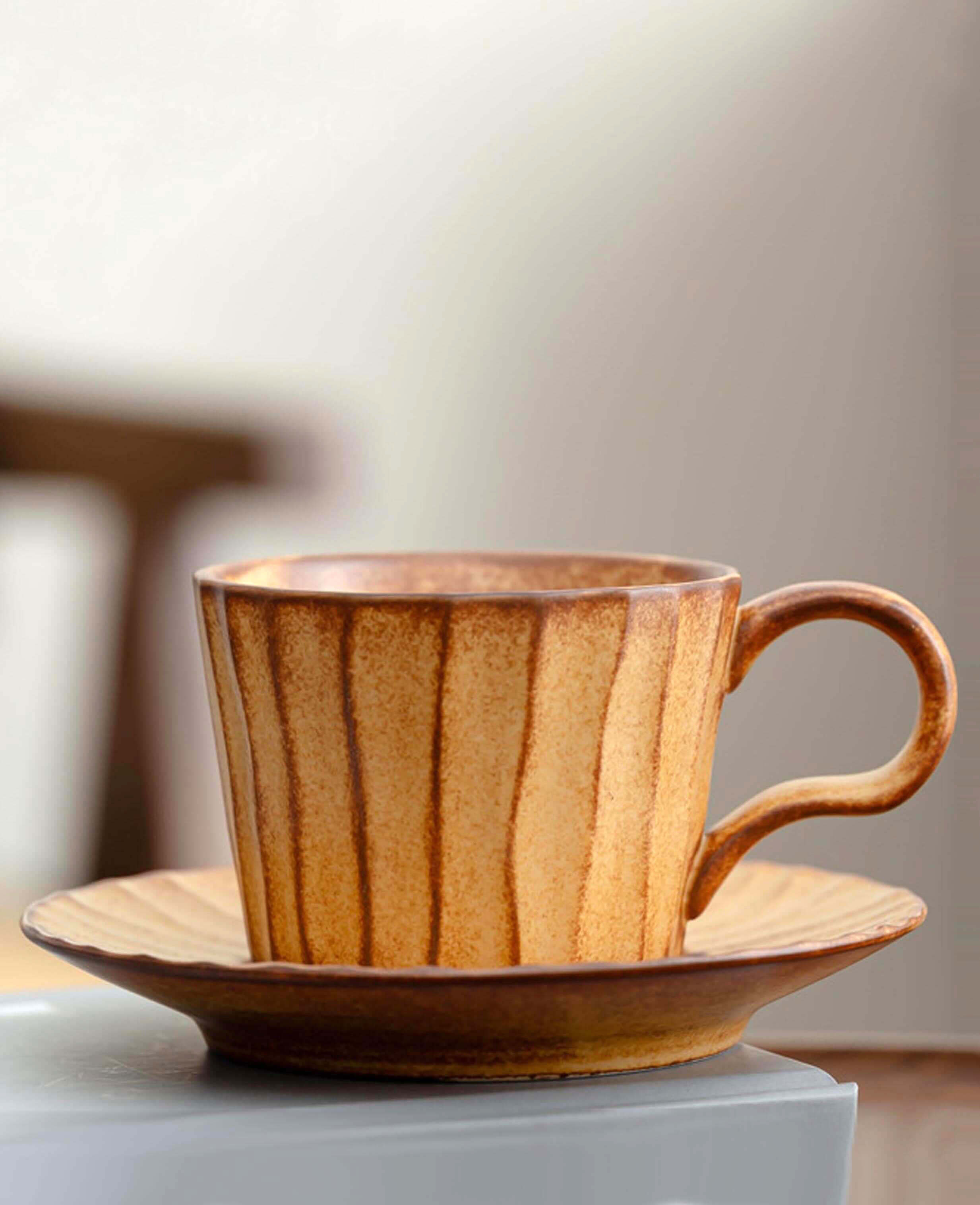 toffee reverie flow handcrafted ceramic coffee cup and saucer set on soft grey background