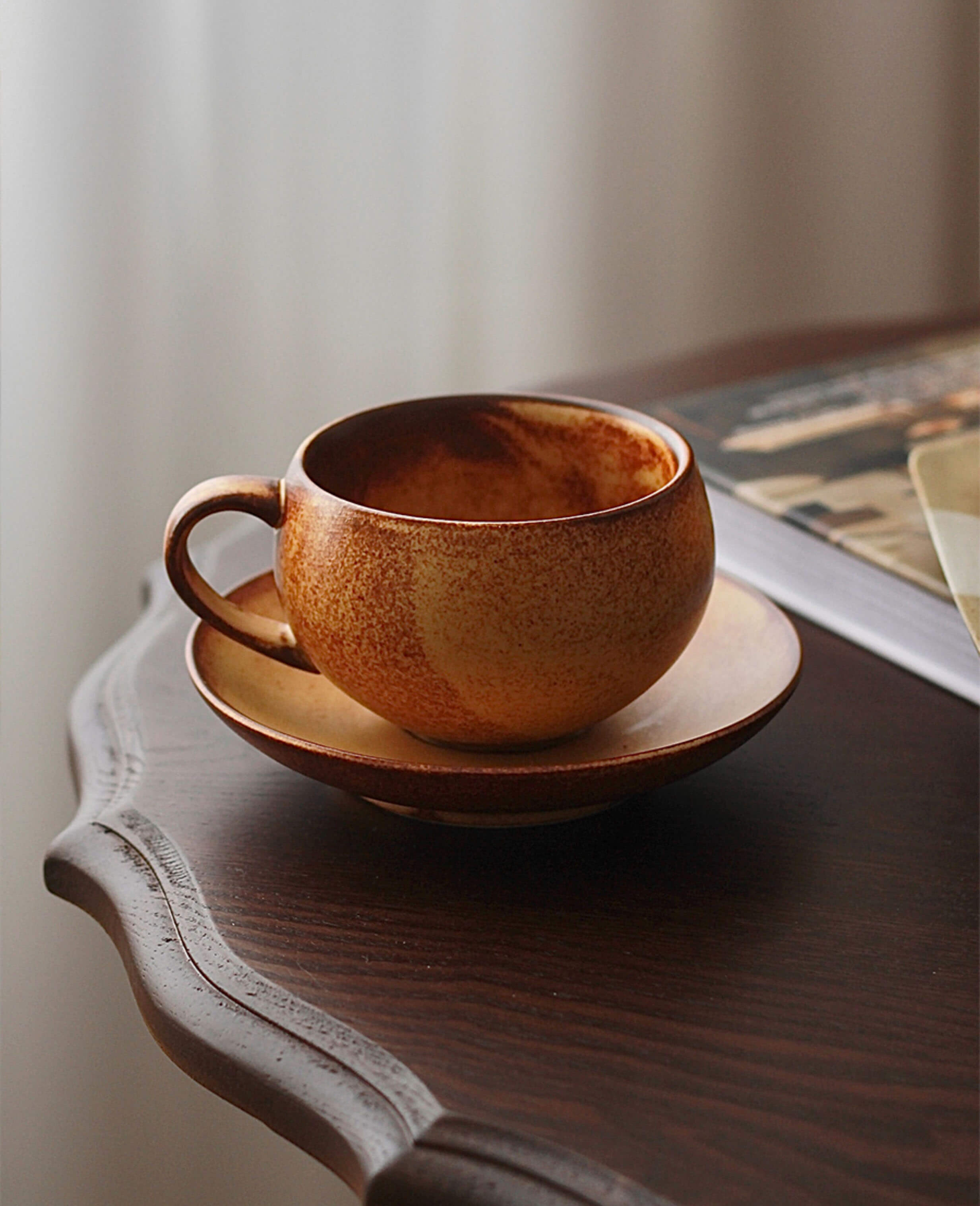 toffee reverie ovolo ceramic coffee cup closeup on wooden surface showing glaze texture