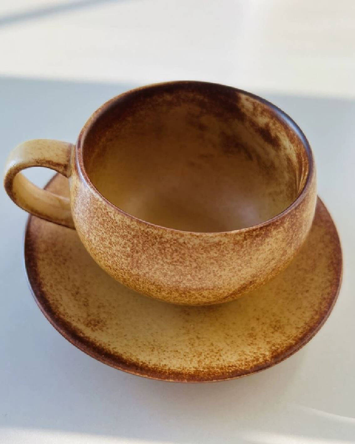 toffee reverie ovolo handcrafted stoneware coffee cup and saucer in natural sunlight from customer testimonial
