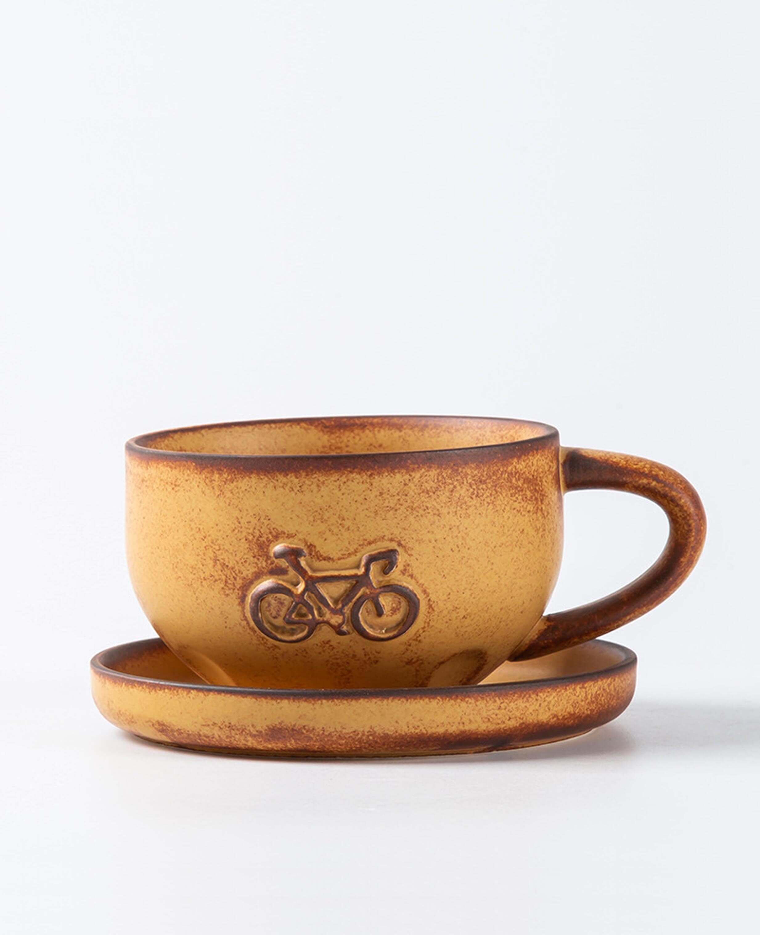 toffee reverie pedalstone coarse pottery coffee mug and saucer with embossed bike pattern front view