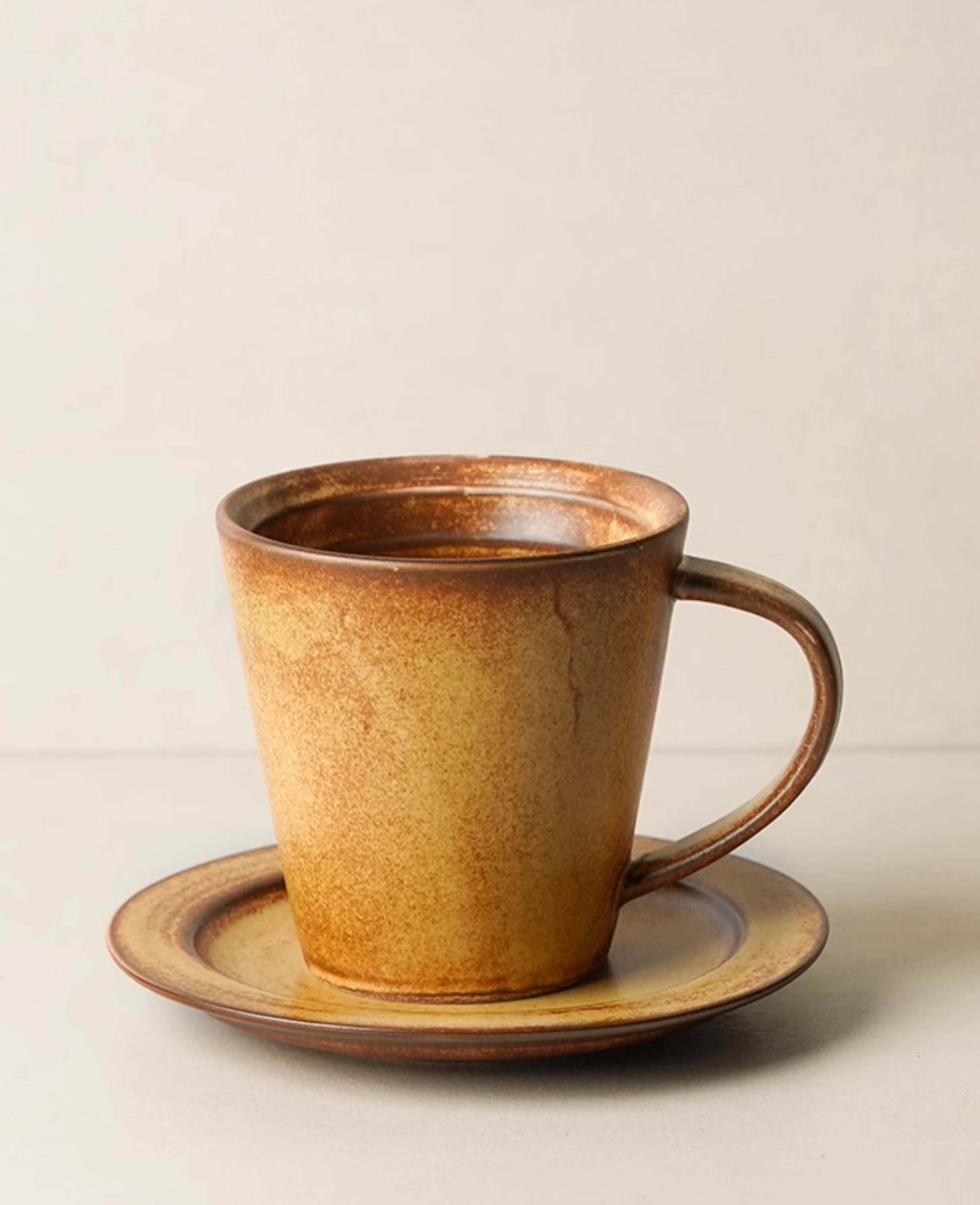 toffee reverie thalen cone shape stoneware coffee mug with matching saucer displayed on light background