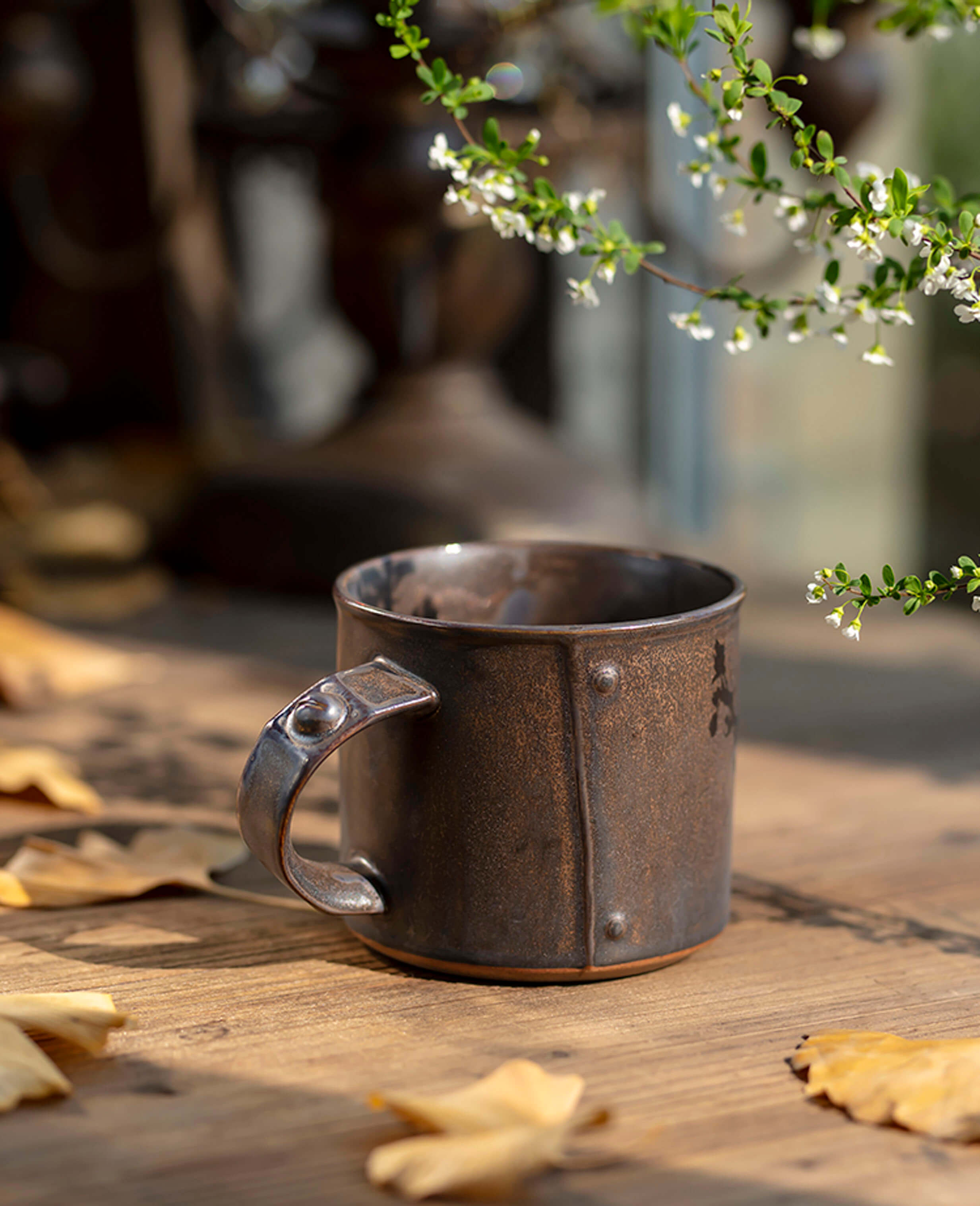 vintage style ironhold mug on wooden surface with flowers and autumn leaves