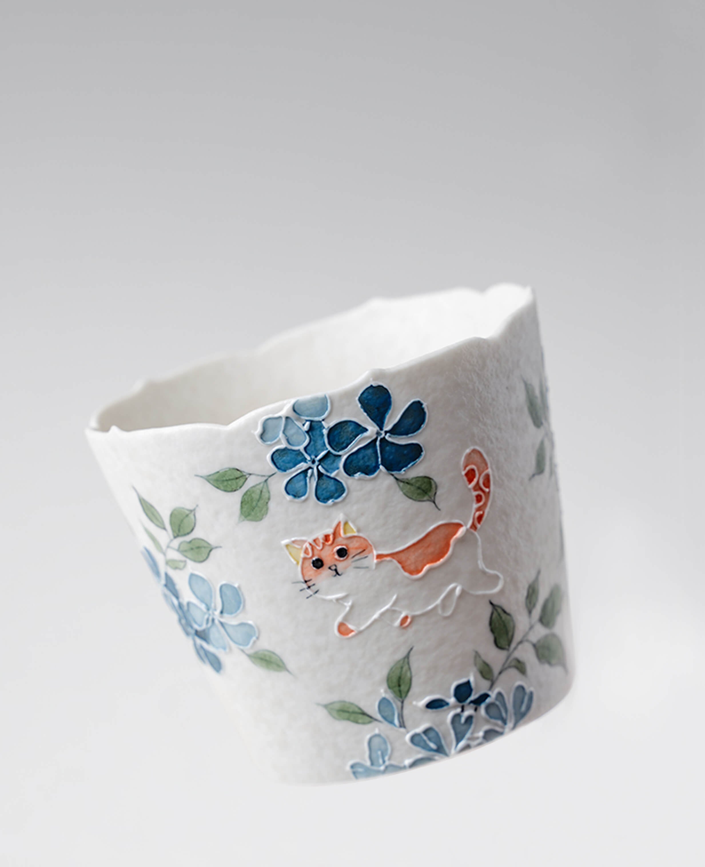 handcrafted whisker trail porcelain coffee and espresso cup showing cat and blue floral design side angle