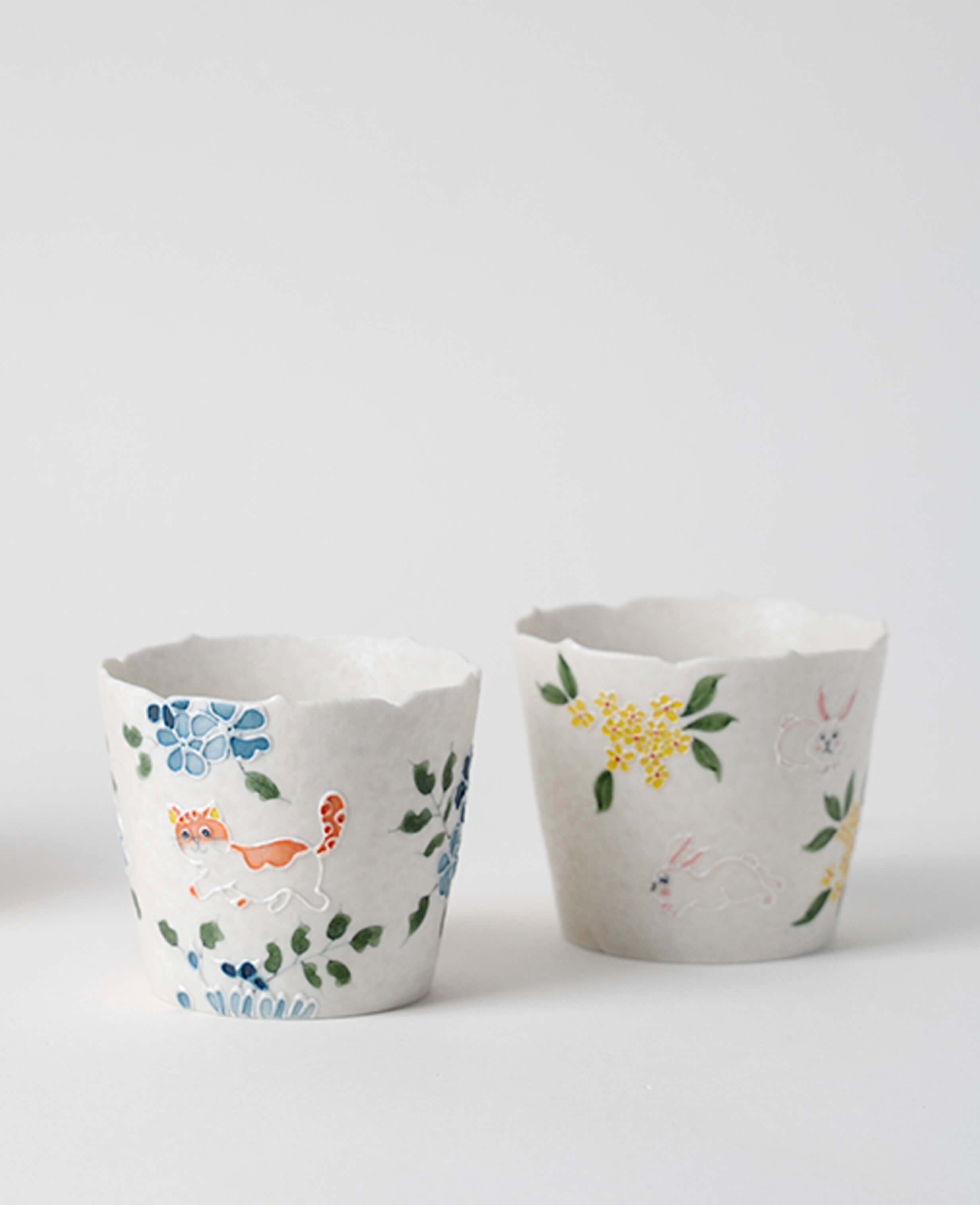 whisker trail handmade porcelain coffee and tea cups with cat and rabbit designs displayed together
