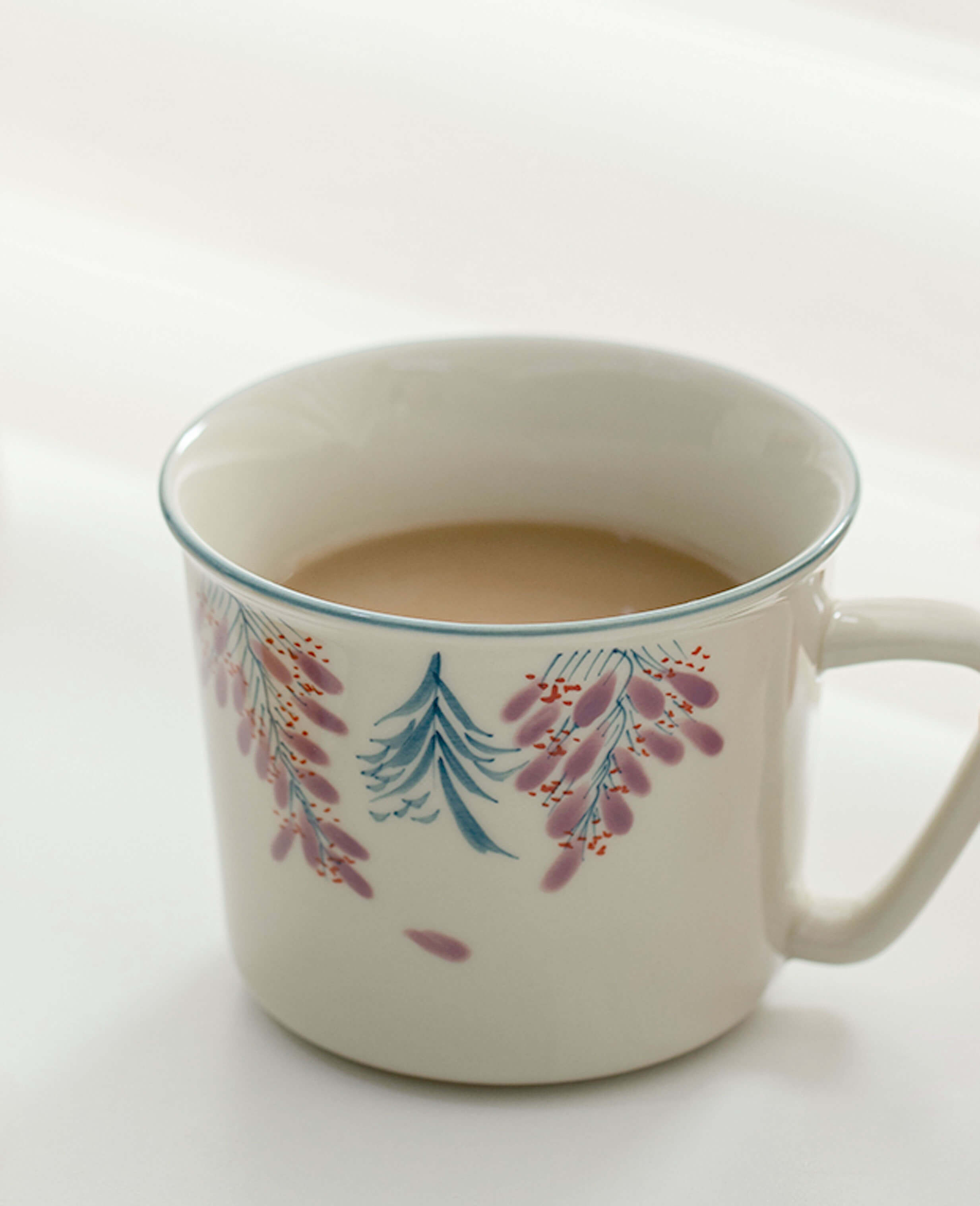 wisteria trace porcelain hand painted coffee cup filled with latte delicate floral artwork under soft natural light