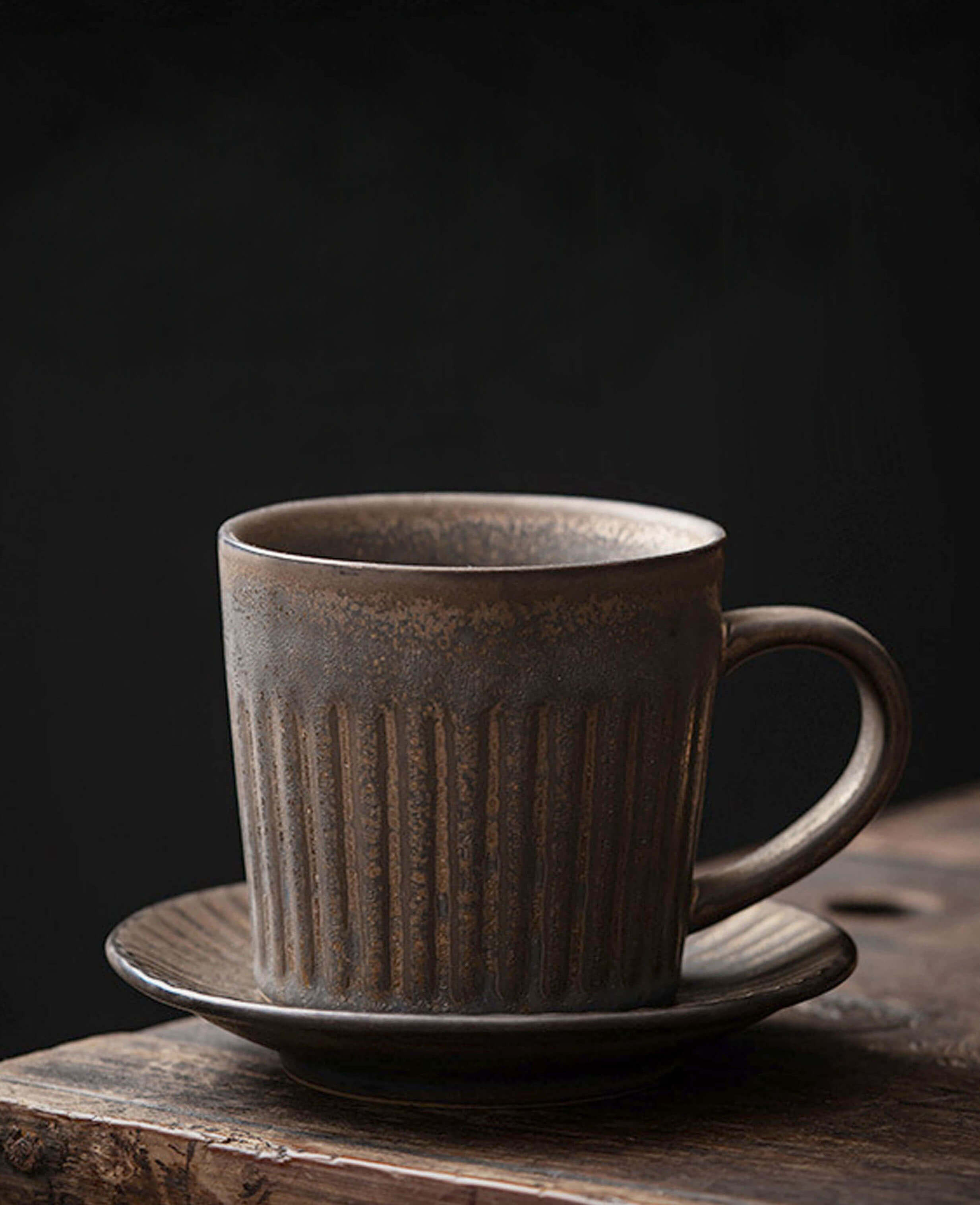 rustglow strata handcrafted ceramic coffee and tea cup with deep brown glaze and vertical texture on dark background