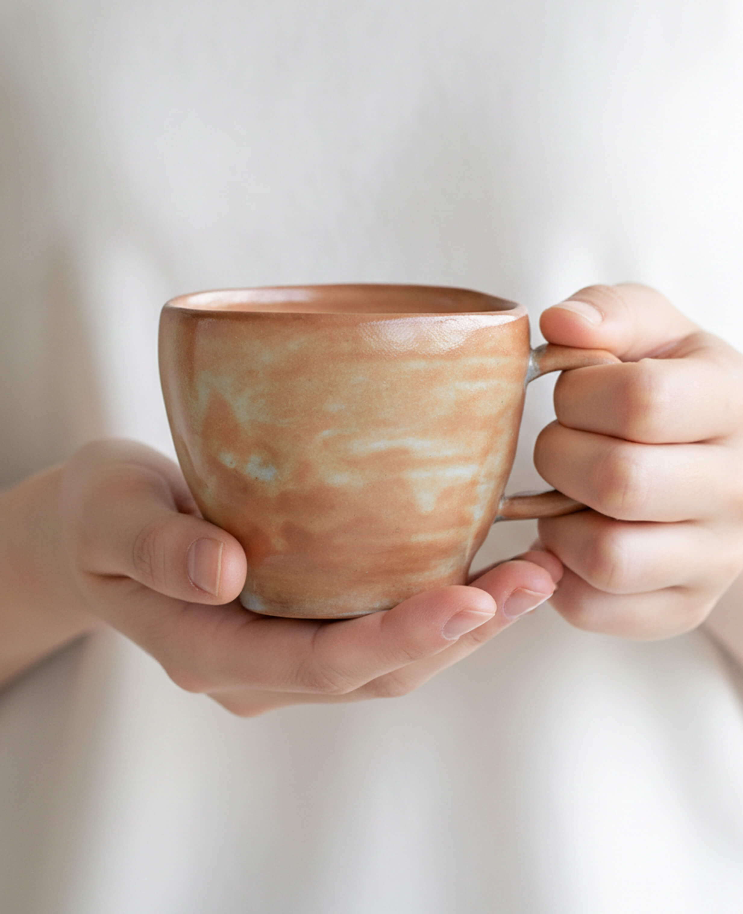 amber veil handmade ceramic pottery coffee cup with warm earthy glaze and organic shape held in hands
