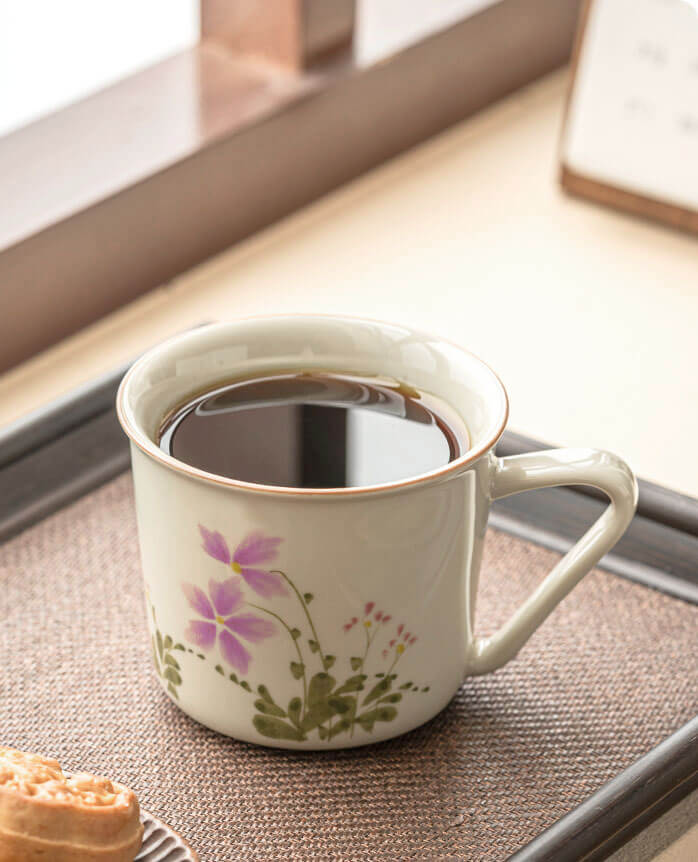 hand painted porcelain coffee and tea cup with pink floral design on wooden surface april verse from the painted diary collection