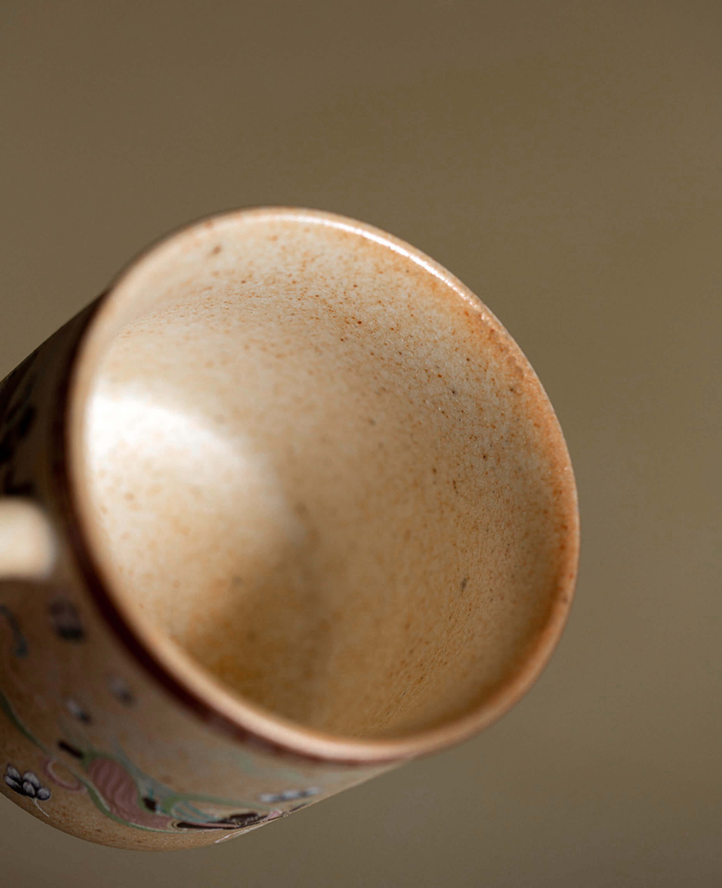 close-up of flying apsaras ceramic cup interior showing speckled stoneware texture