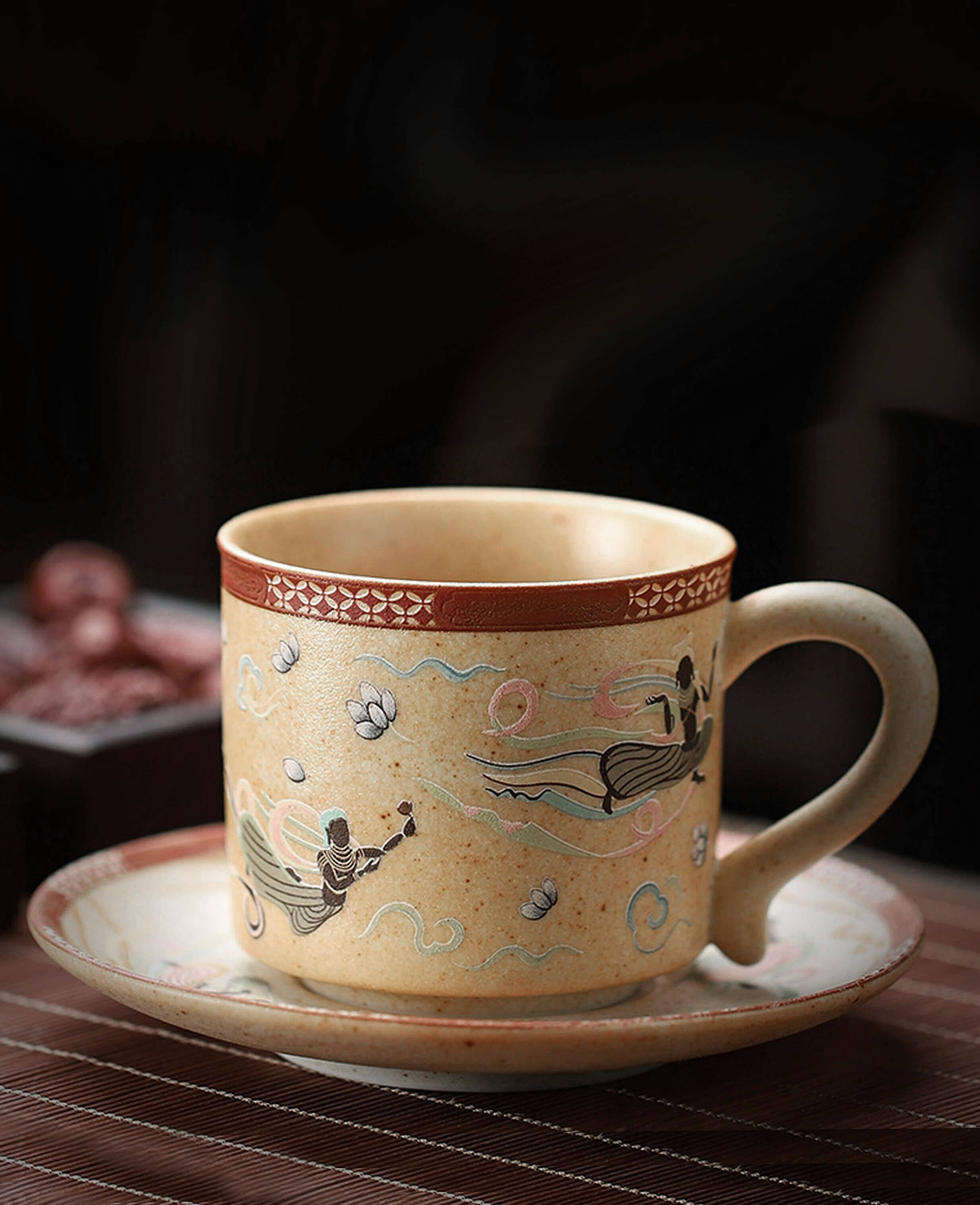 ceramic coffee cup and saucer featuring flying apsara design placed on wooden table