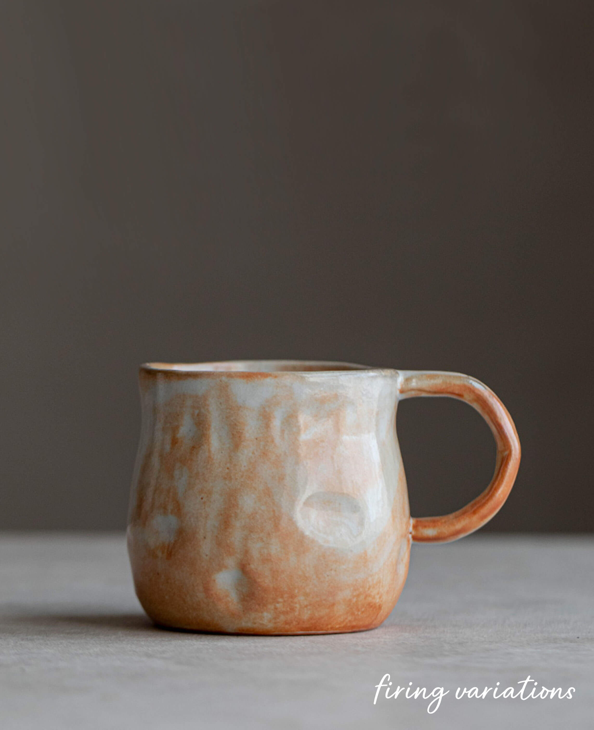 earth toned stoneware coffee and tea cup profile snowcrest wood fired flame glaze against dark moody backdrop