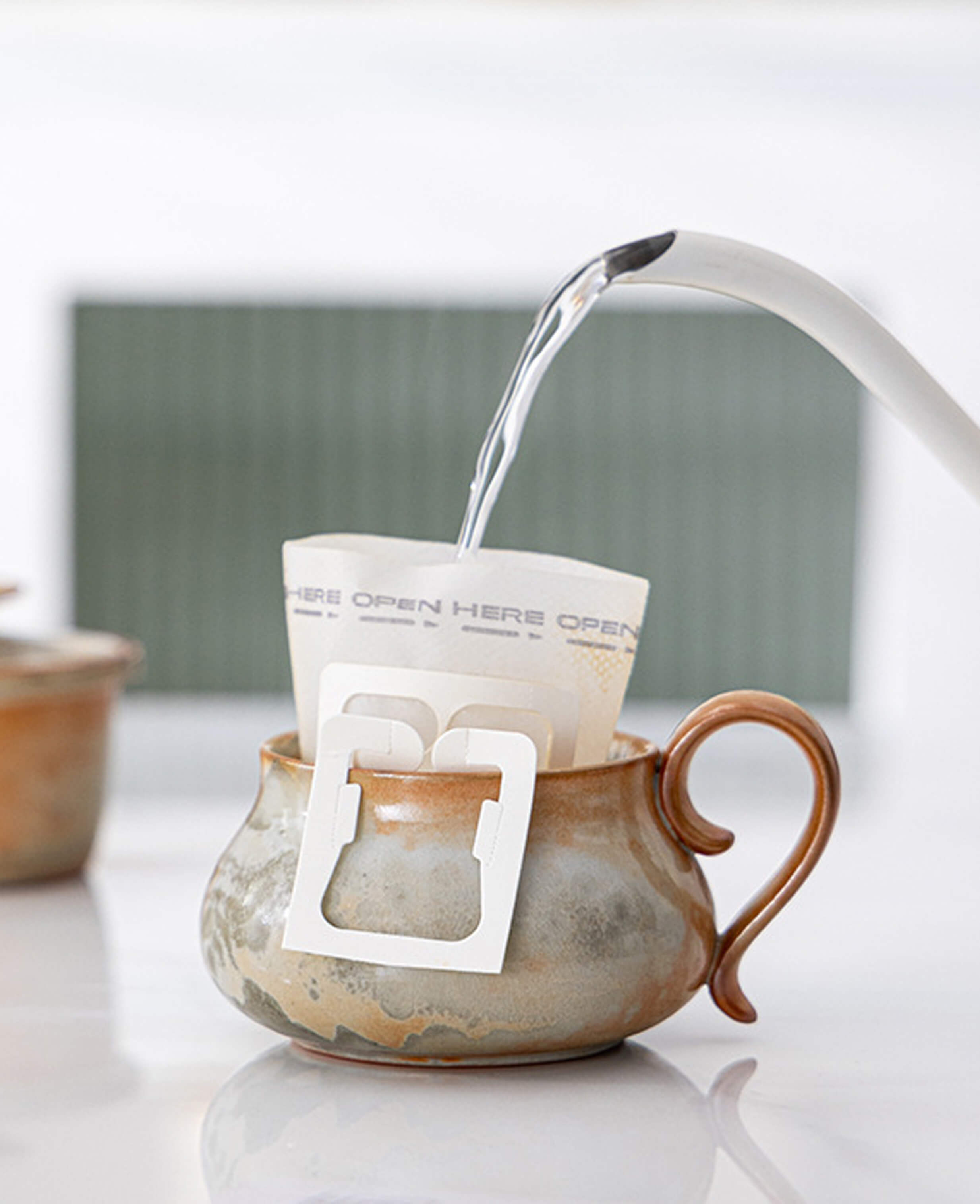 handcrafted cloudstone ceramic coffee mug being used for pour over filter coffee showing wood fired texture