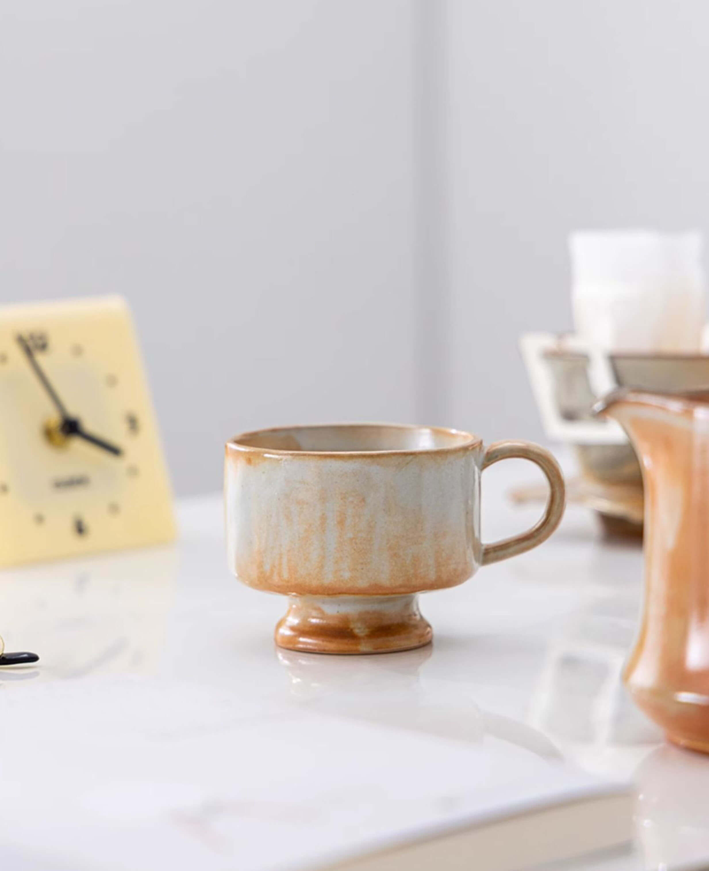 dawn chalice handcrafted ceramic coffee and tea cup on desk with warm terracotta and soft cream glaze  minimalist morning scene