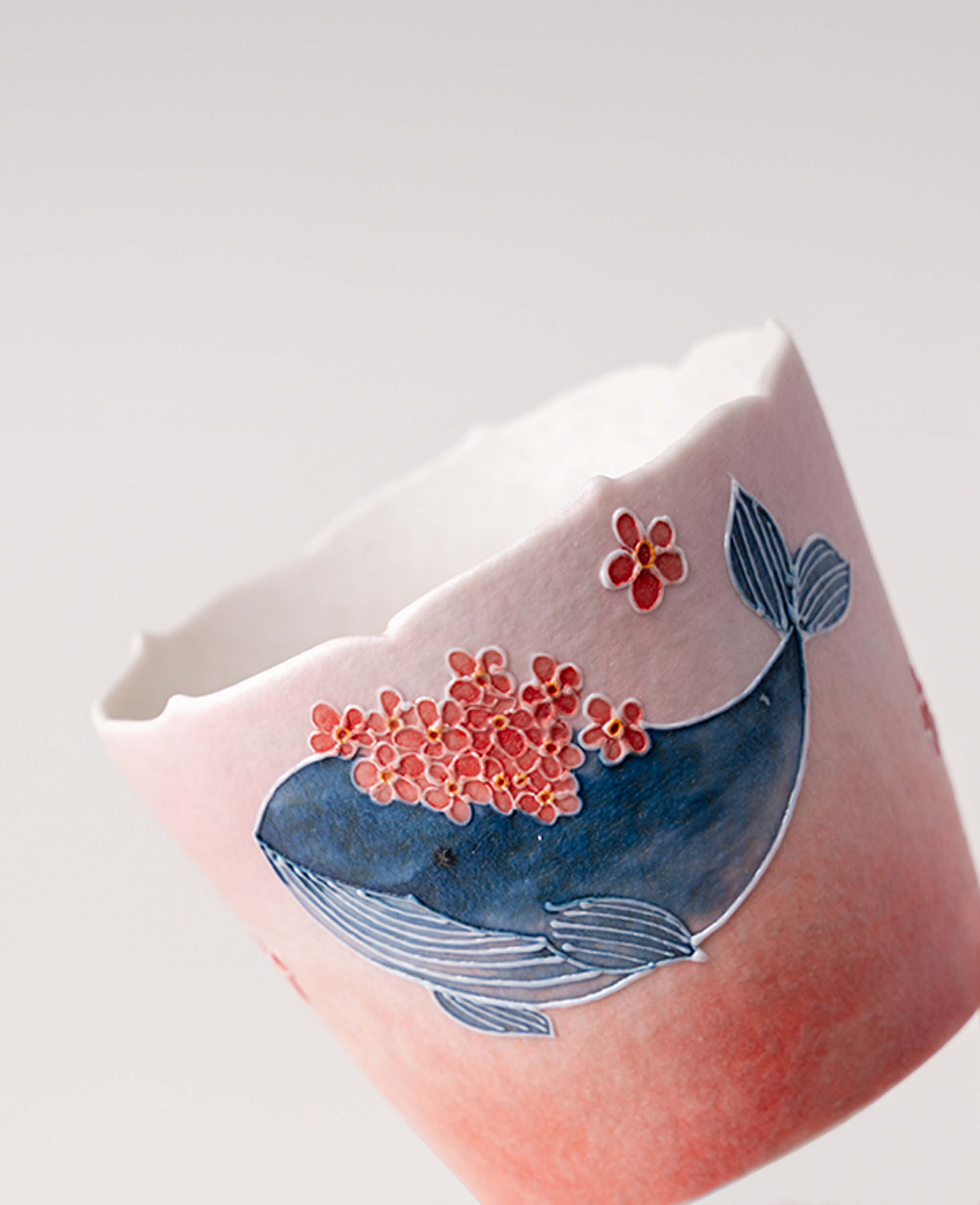 dream tide handmade porcelain coffee tea cup showing whale and flower pattern angled view