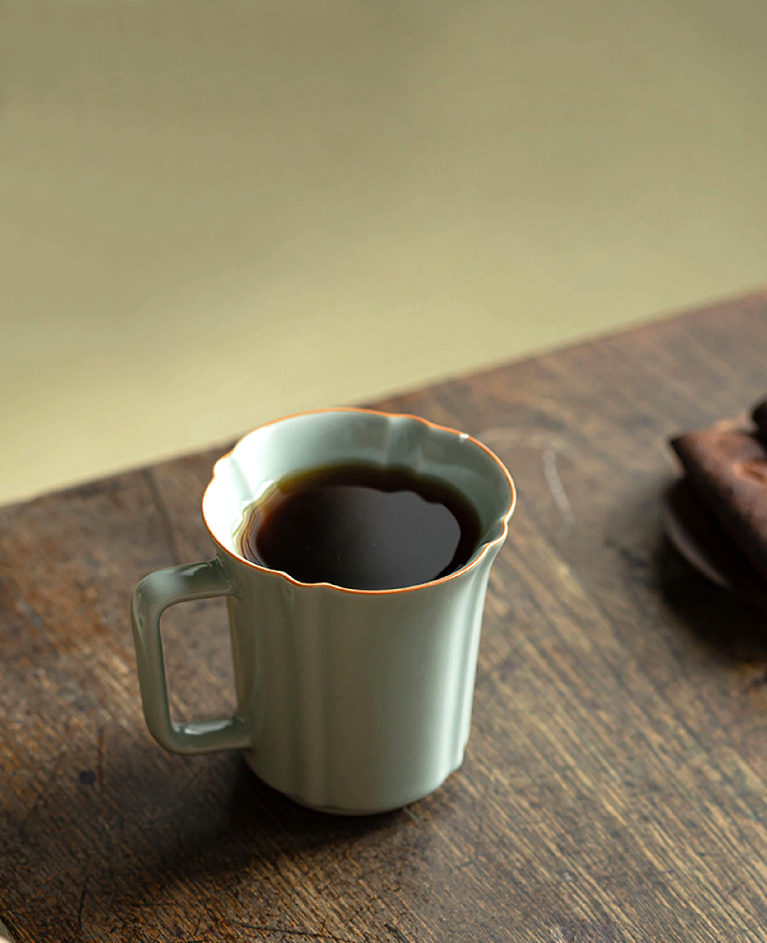 echo of ru porcelain mug filled with coffee on wooden table with soft background