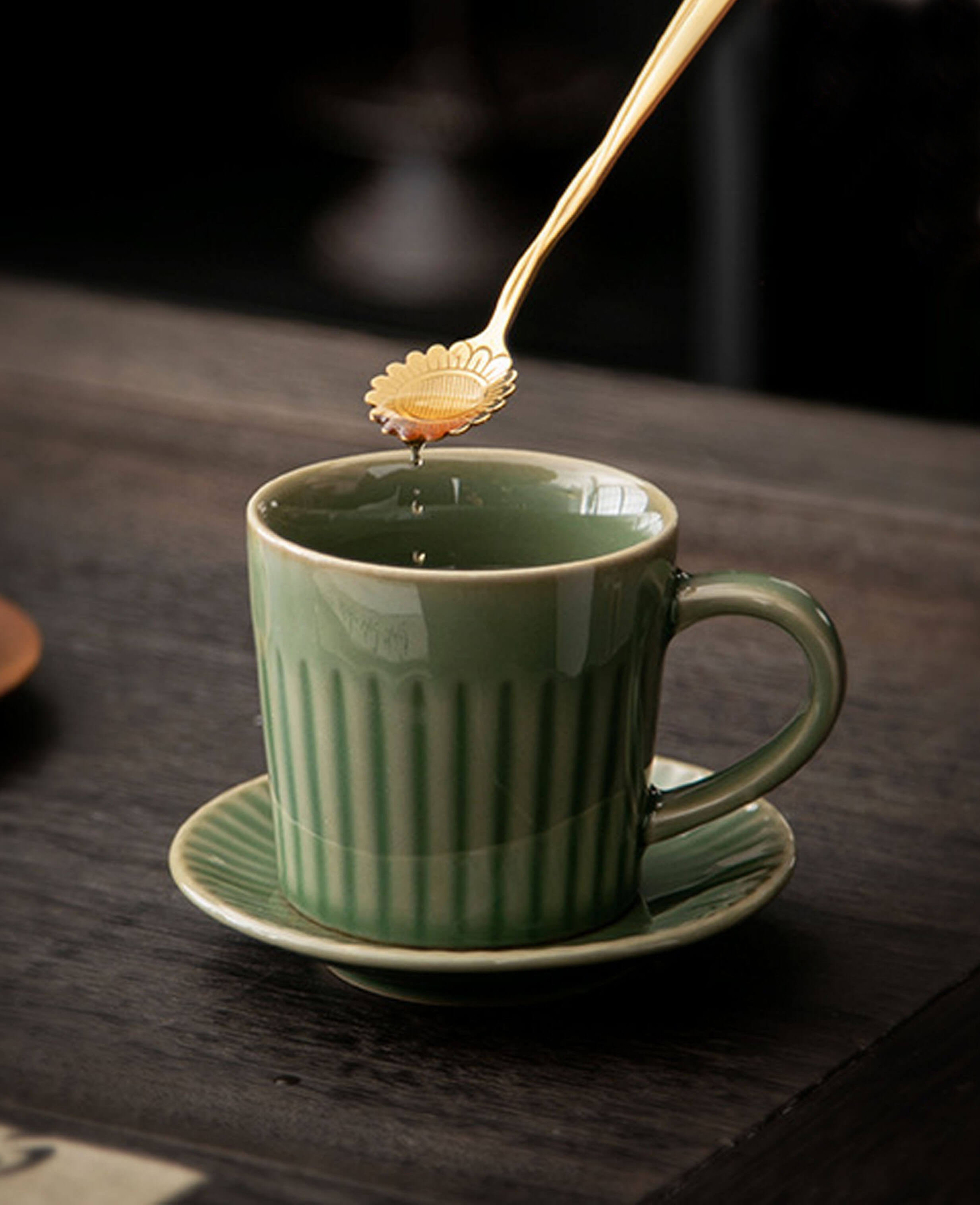 greenstill whisper porcelain coffee mug and saucer with golden spoon dripping honey