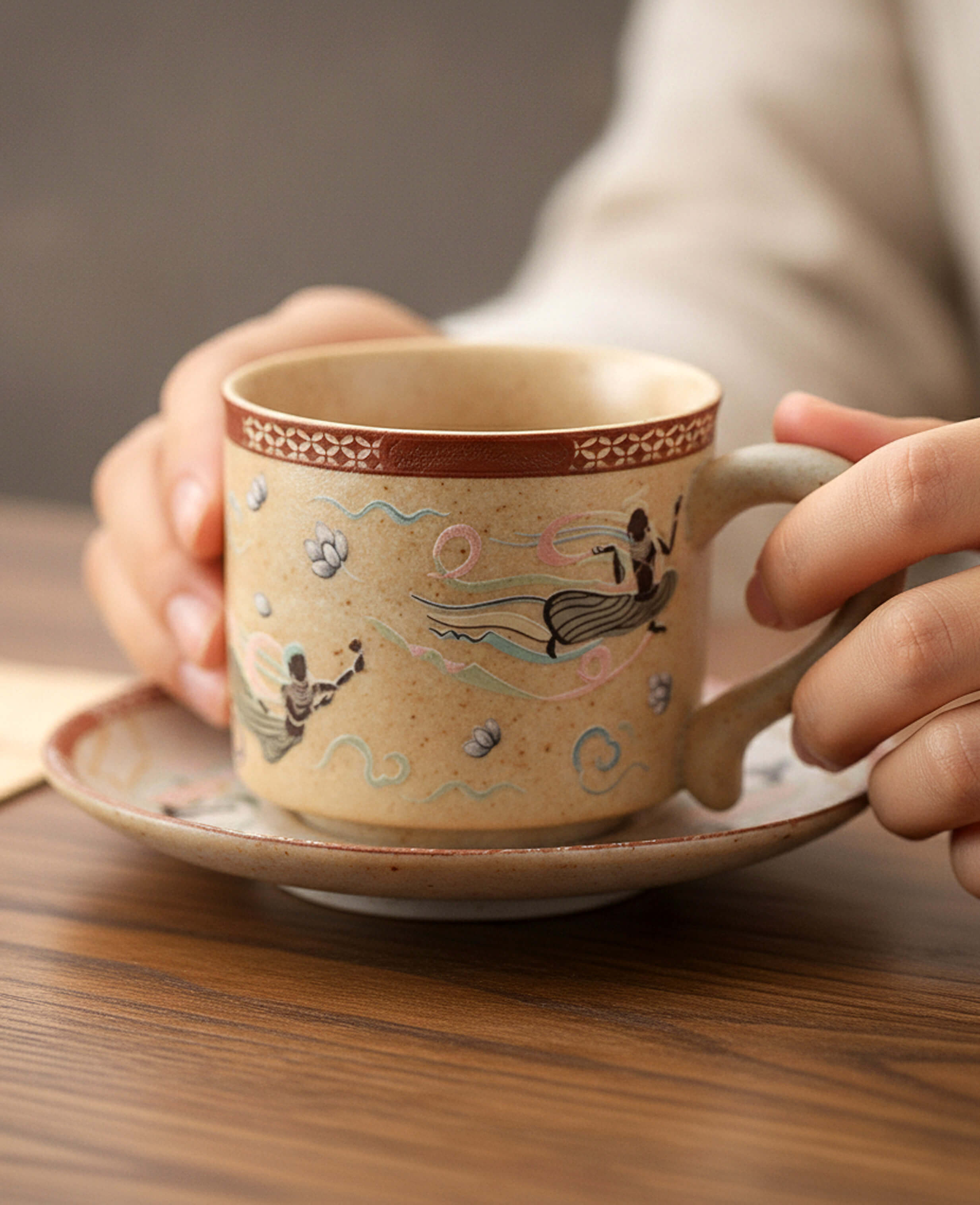 handcrafted ceramic coffee cup with flying apsaras pattern held in hands
