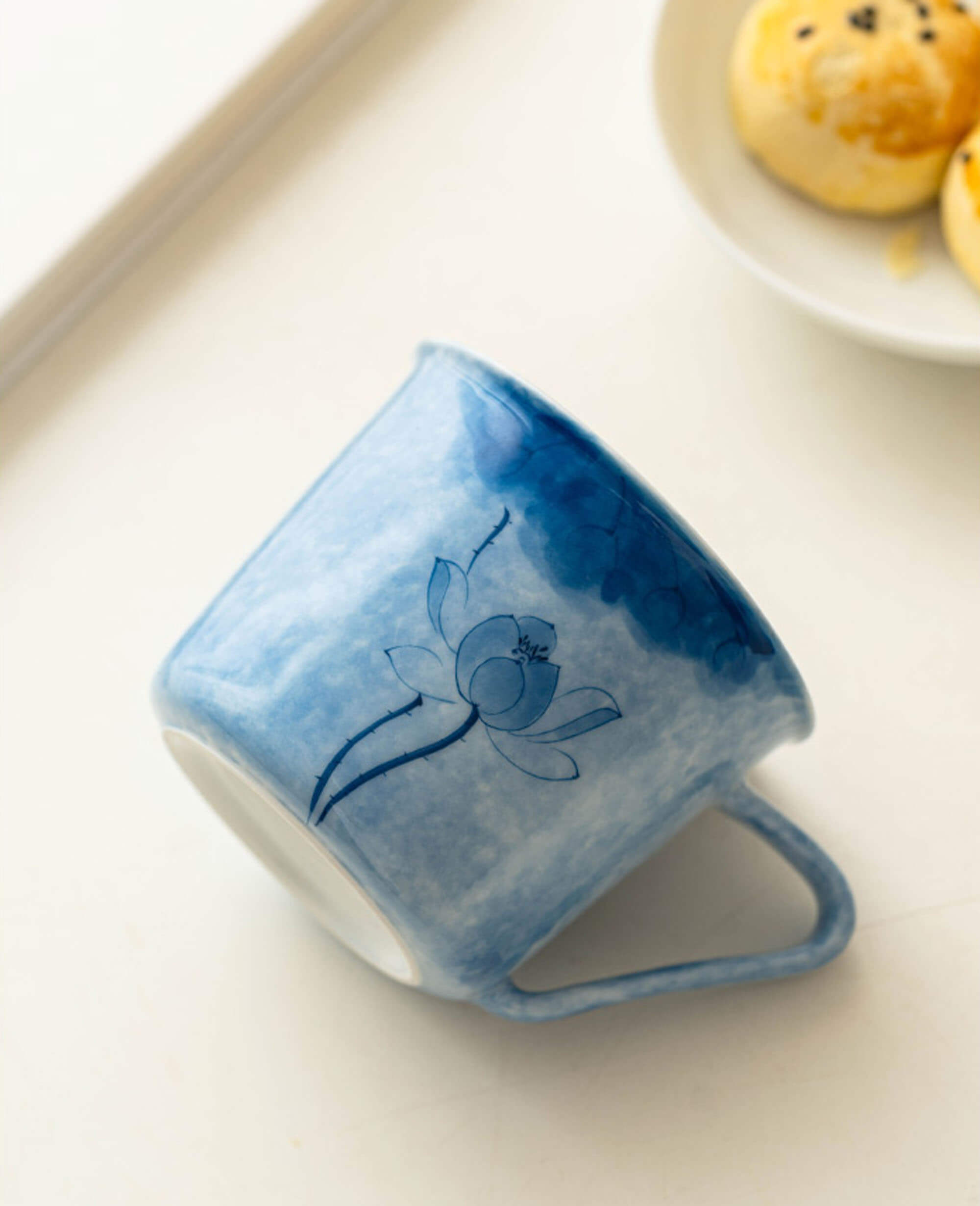side view of inked drizzle blue lotus coffee and tea cup with hand painted floral artwork