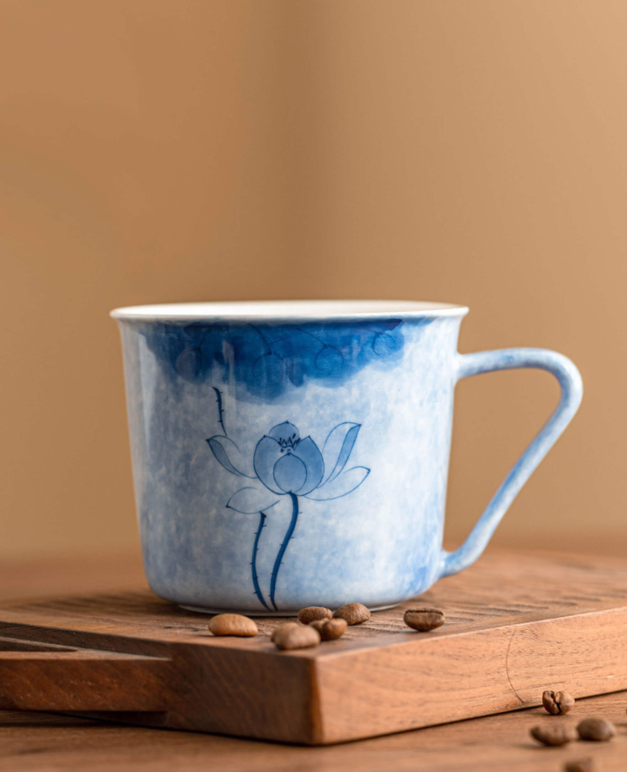 porcelain coffee and tea cup with lotus flower resting on wooden board from the hand painted diary series