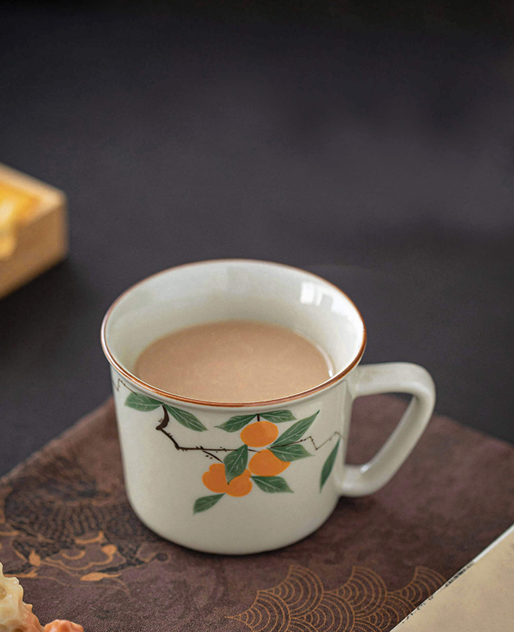 mellow blessing hand painted persimmon porcelain coffee and tea cup placed on book from painted diary collection