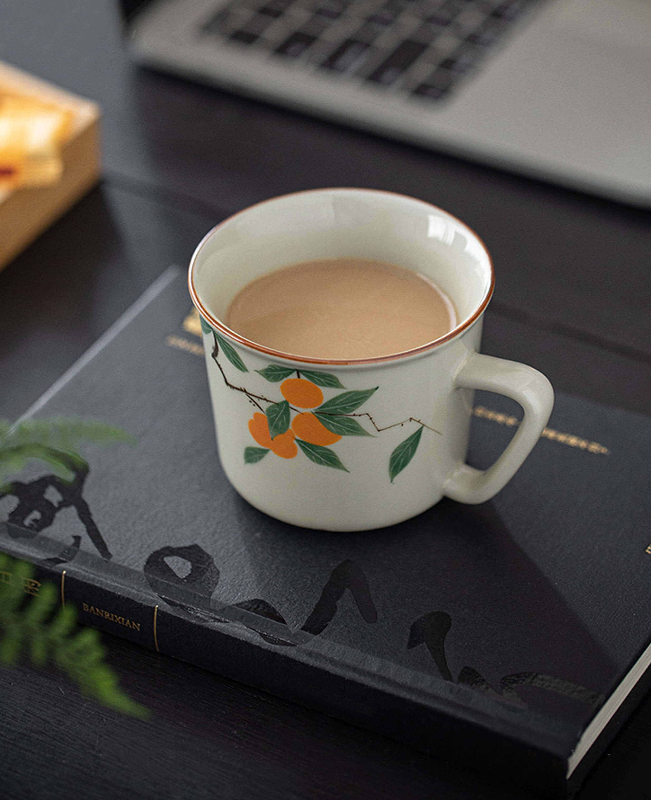 side view of mellow blessing porcelain tea and coffee cup featuring hand painted persimmon design from painted diary collection