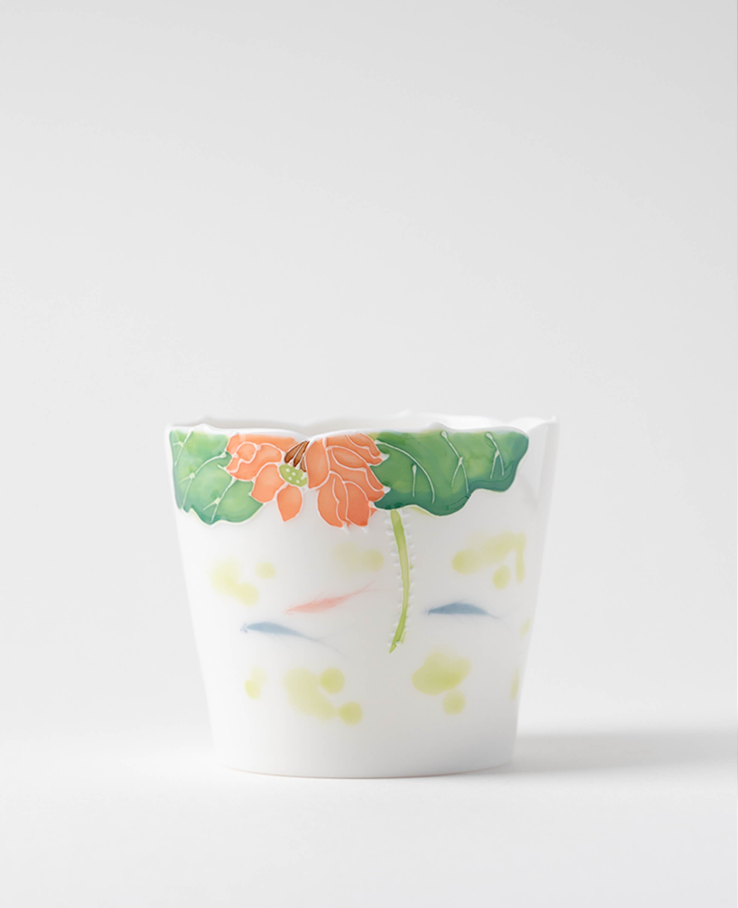 handcrafted porcelain coffee and tea cup decorated with lotus flower and water motif displayed on white background