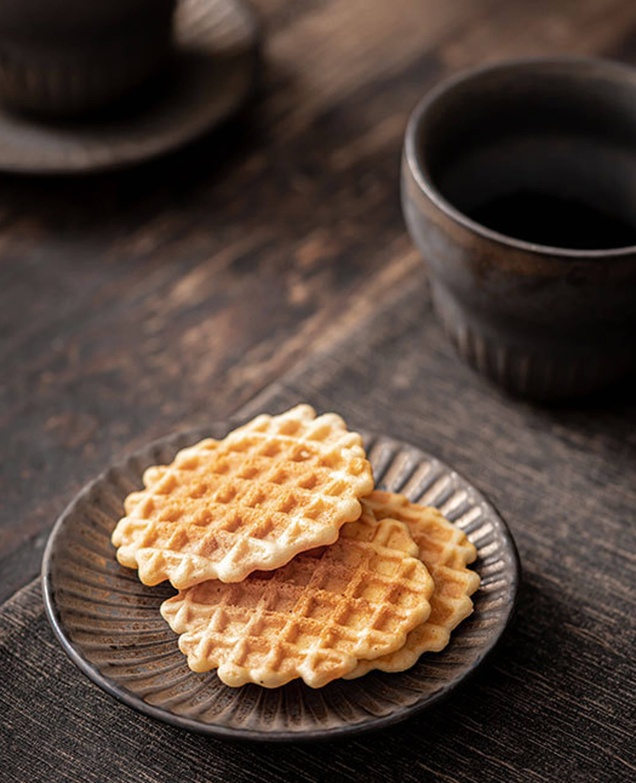 rustglow crest ceramic coffee cup and saucer with biscuits on table