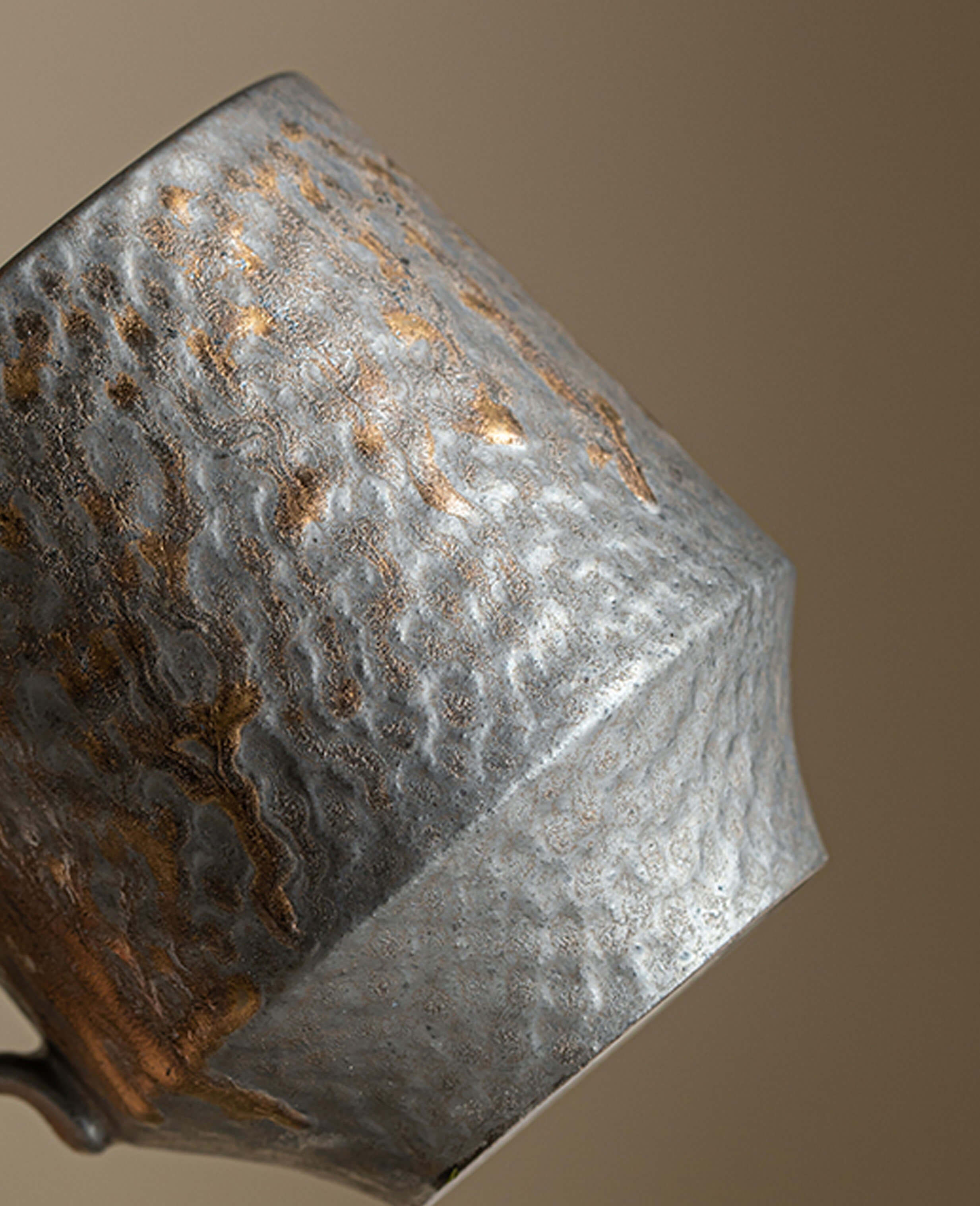 side view of the rustglow obel cup highlighting hammered texture and warm rust toned glaze