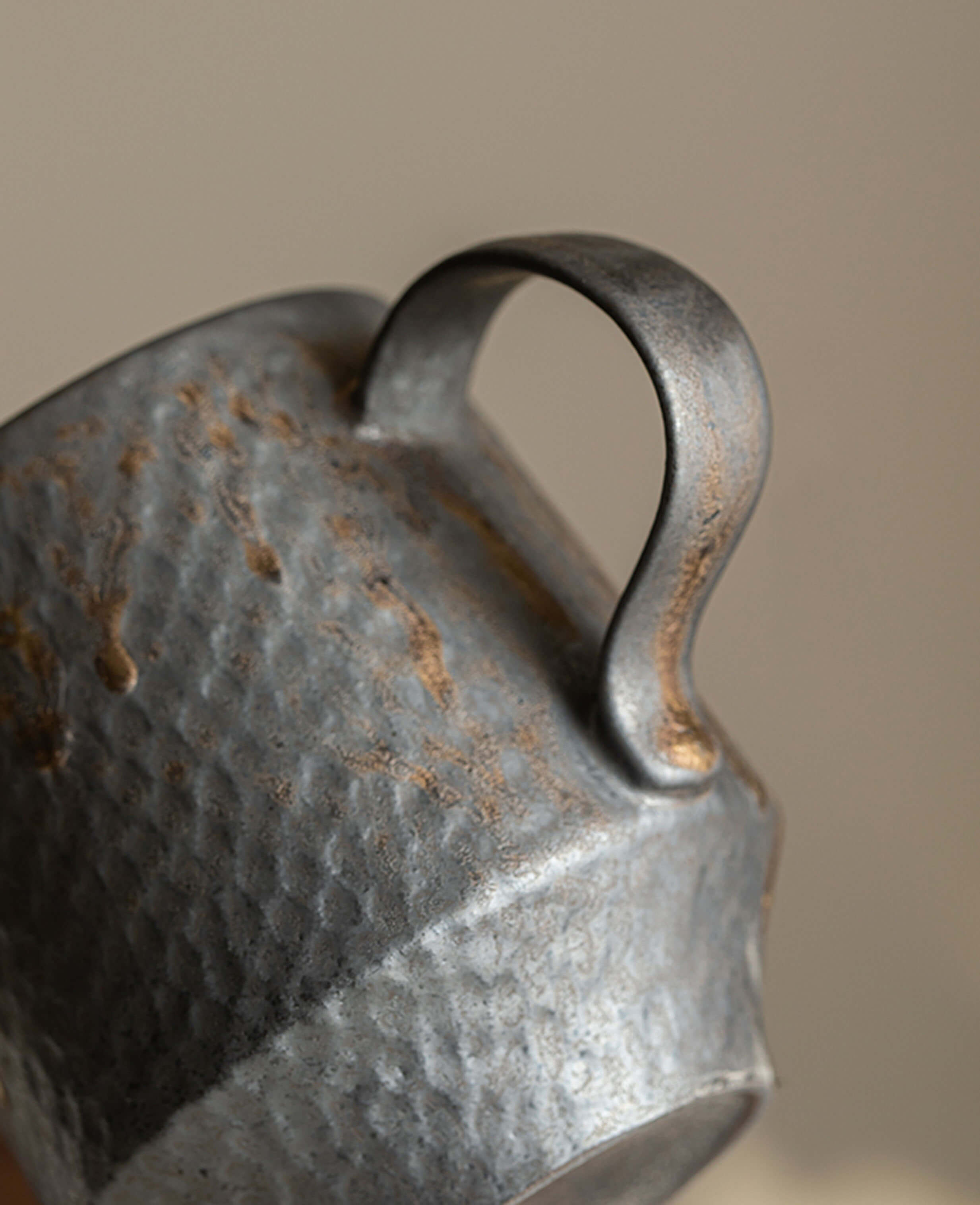 close up of rustglow obel mug handle showing sculptural form and metallic glaze textures
