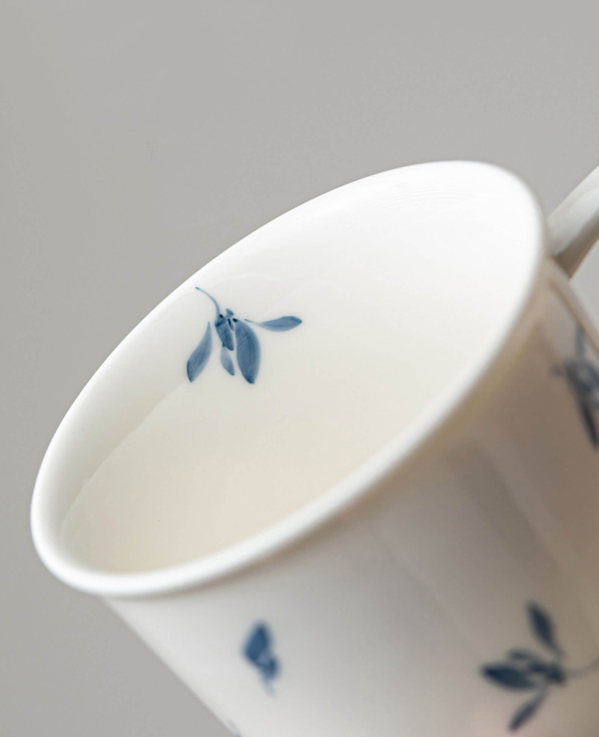 interior view of serene drift cup showing delicate blue leaf design near the rim hand painted porcelain from the painted diary collection