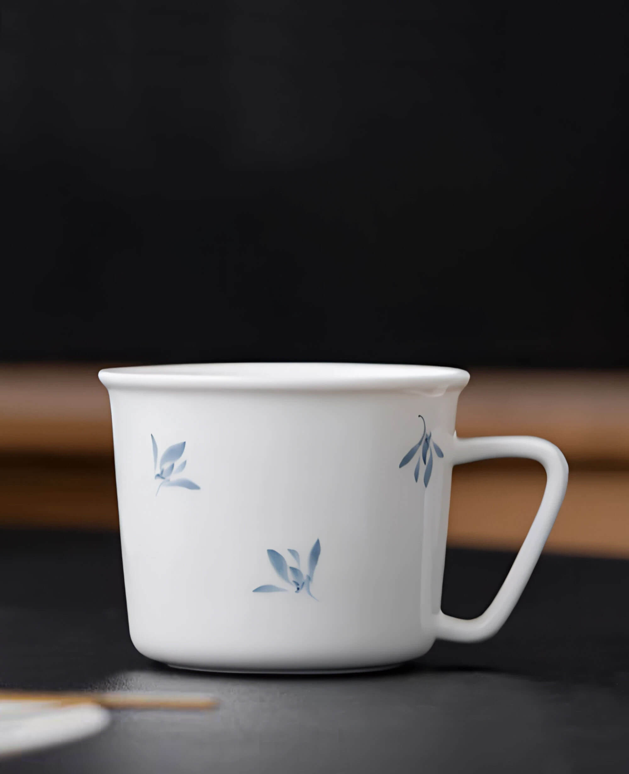 side profile of serene drift porcelain cup featuring hand painted blue botanical brushstrokes from the painted diary collection