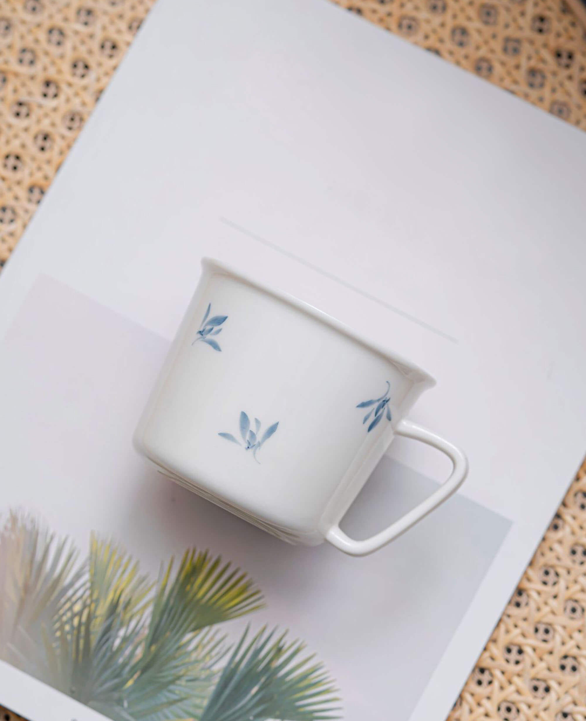 serene drift porcelain tea cup styled atop magazine with soft rattan texture background from the painted diary collection