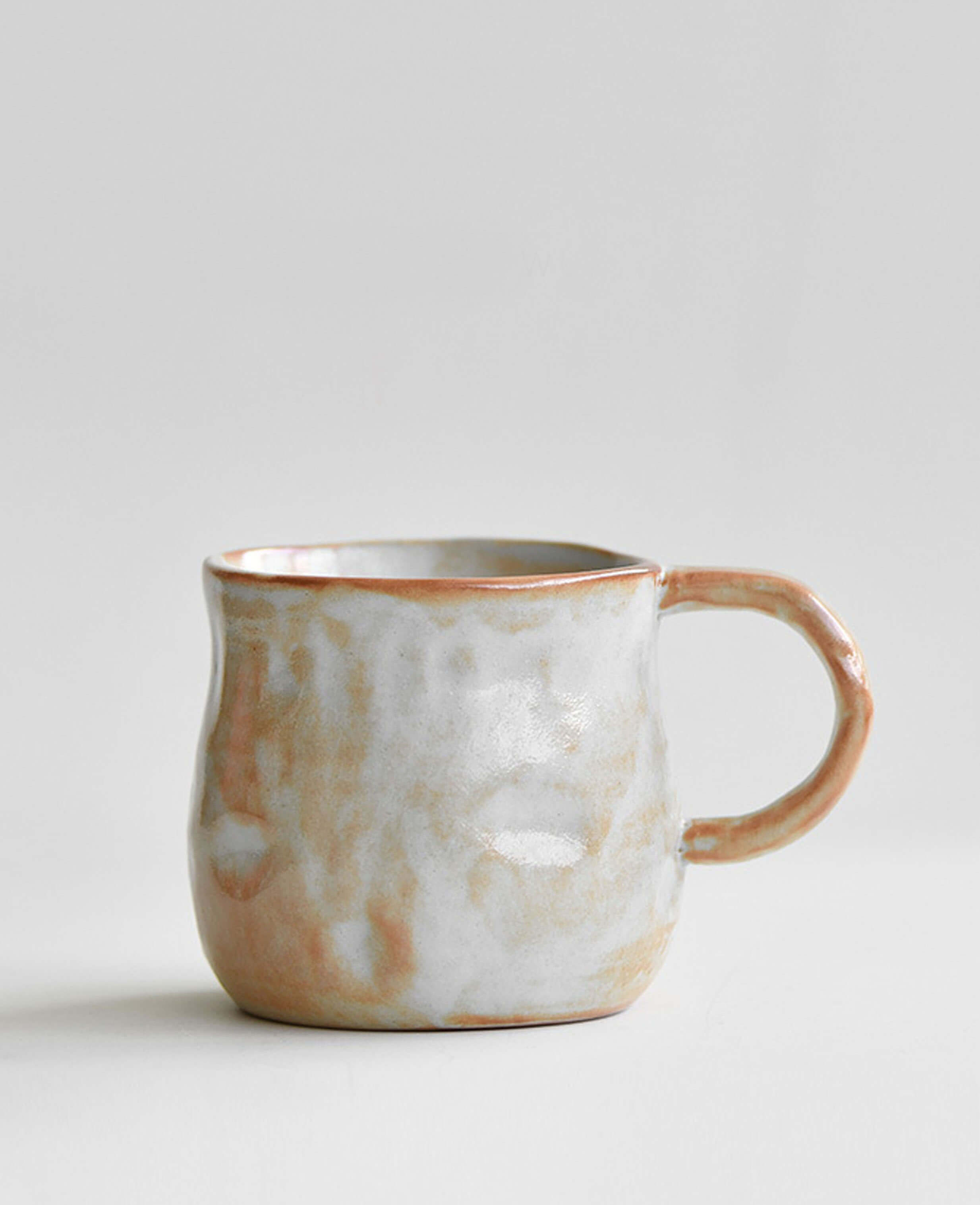wheel thrown stoneware coffee and tea cup profile snowcrest wood fired flame glaze against light minimalist background